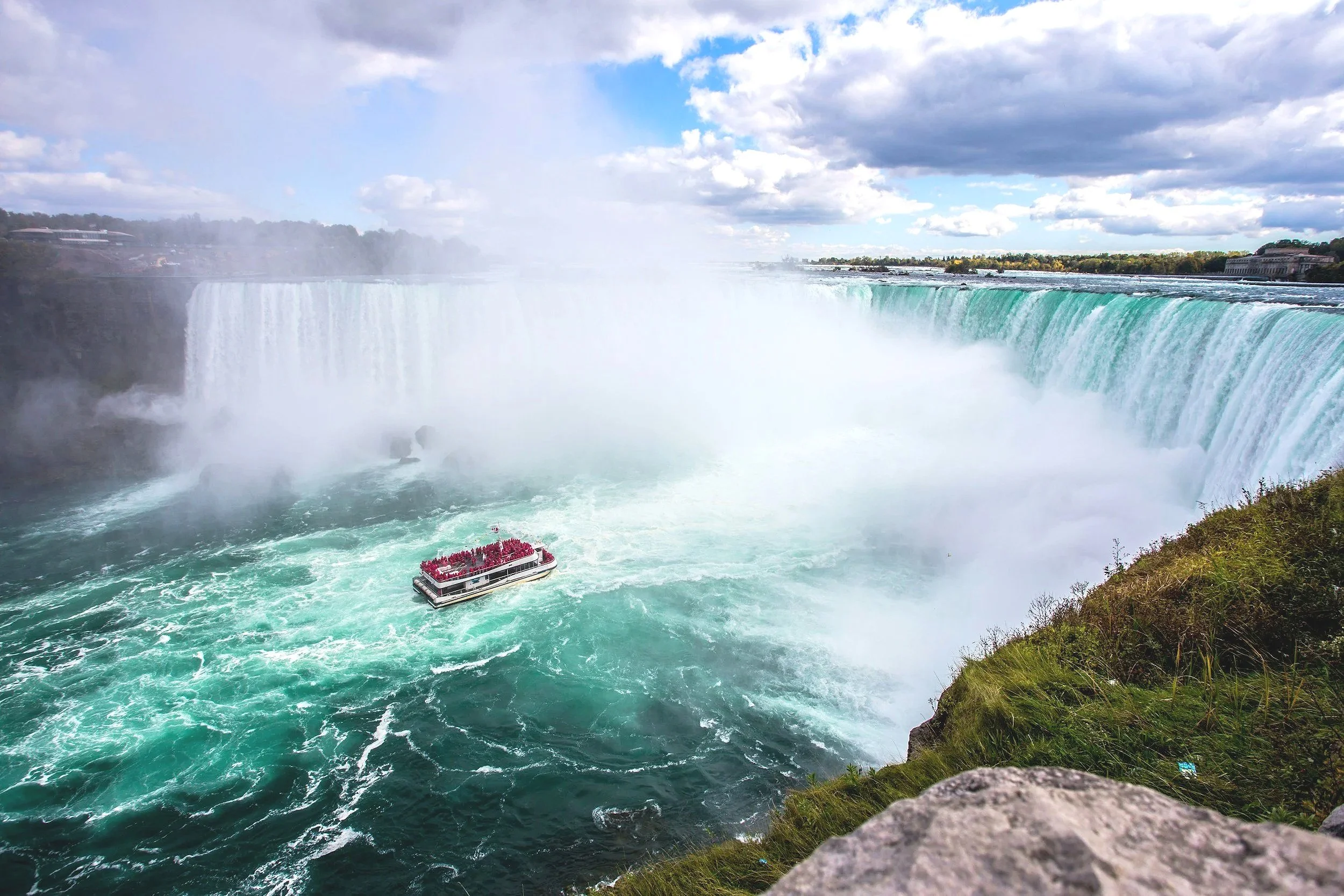 Niagara Falls with a boat near the base of the falls.