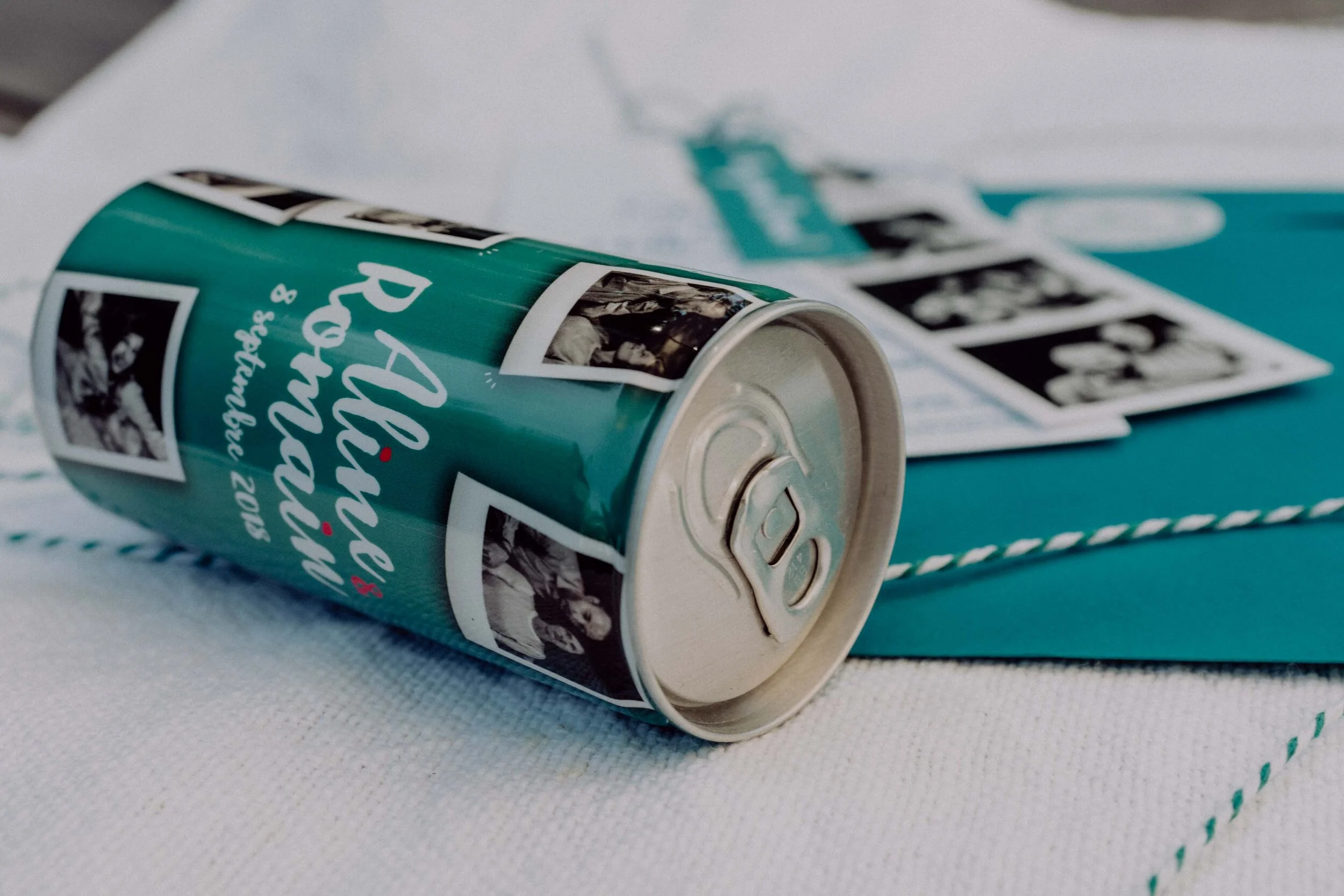 Une canette de soda positionnée horizontalement sur une surface avec une image noire et blanche de personnes dessus, accompagnée de texte en français.