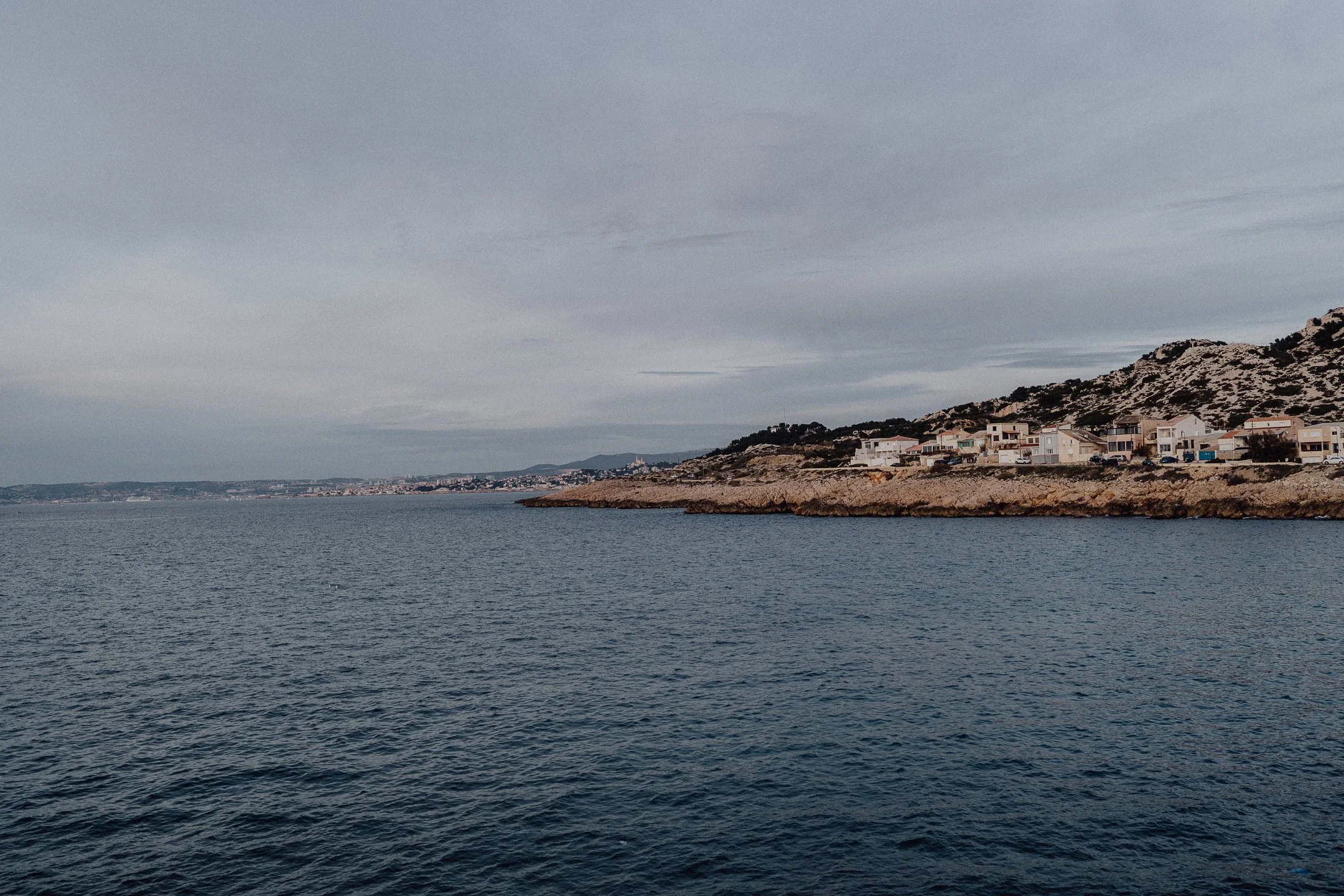 Les Goudes, au bord de l'eau, Marseille en fond