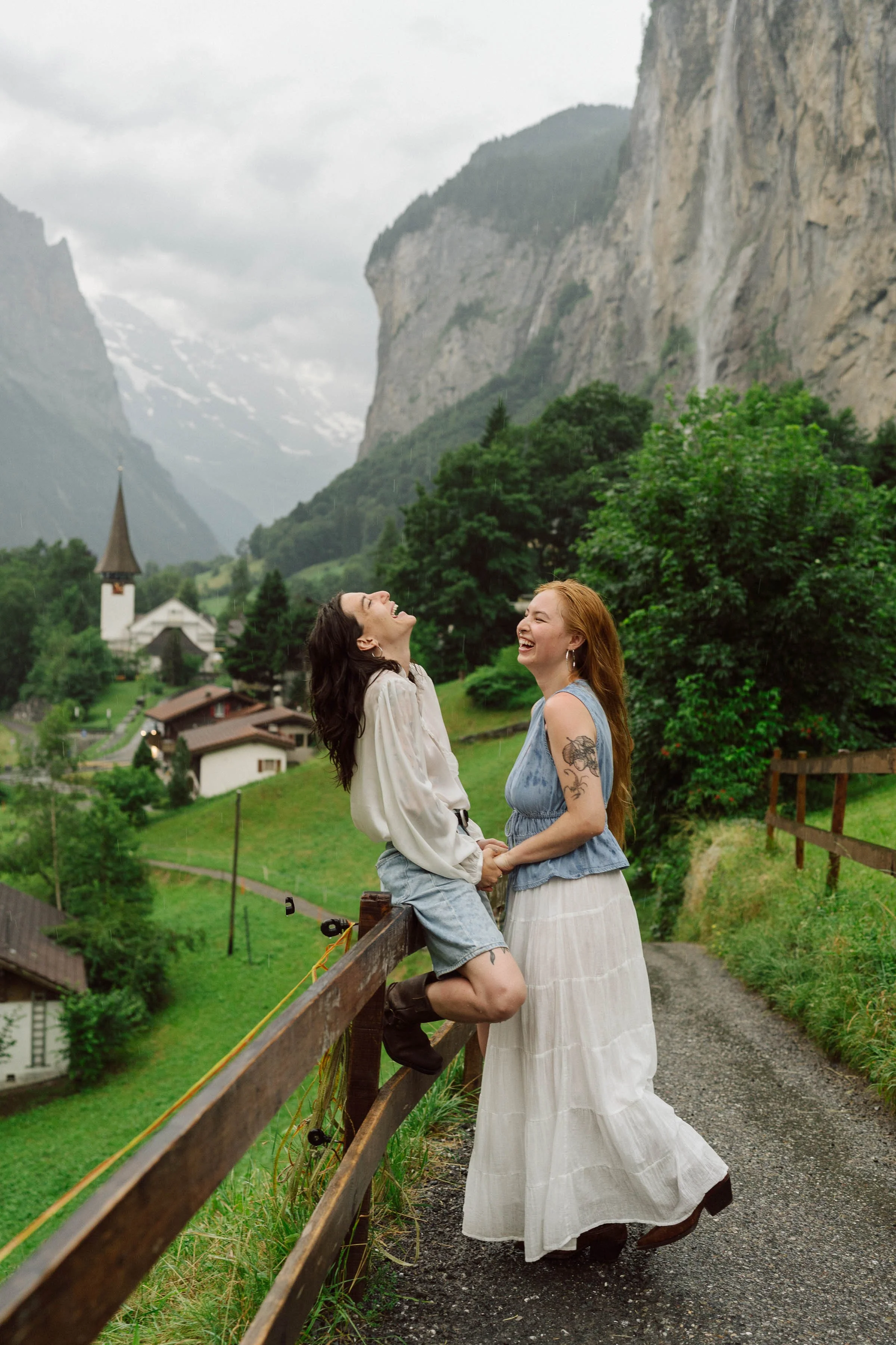 Séance photo couple à Lauterbrunnen en Suisse : deux femmes partagent un moment de joie au cœur des montagnes et cascades alpines, capturé dans une ambiance naturelle et authentique par Nonante Émotions.