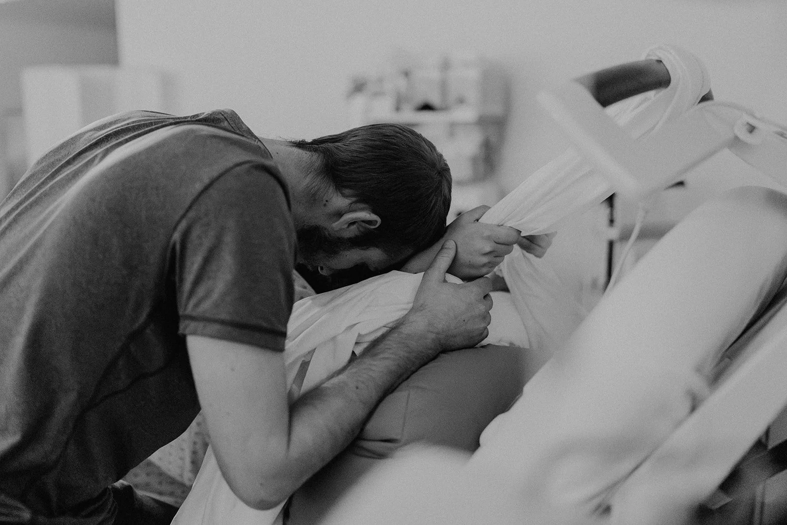 Le soutien précieux du partenaire pendant le travail, un moment d’intimité et de force capturé lors d’un reportage d’accouchement en Suisse romande, au cœur de la naissance.