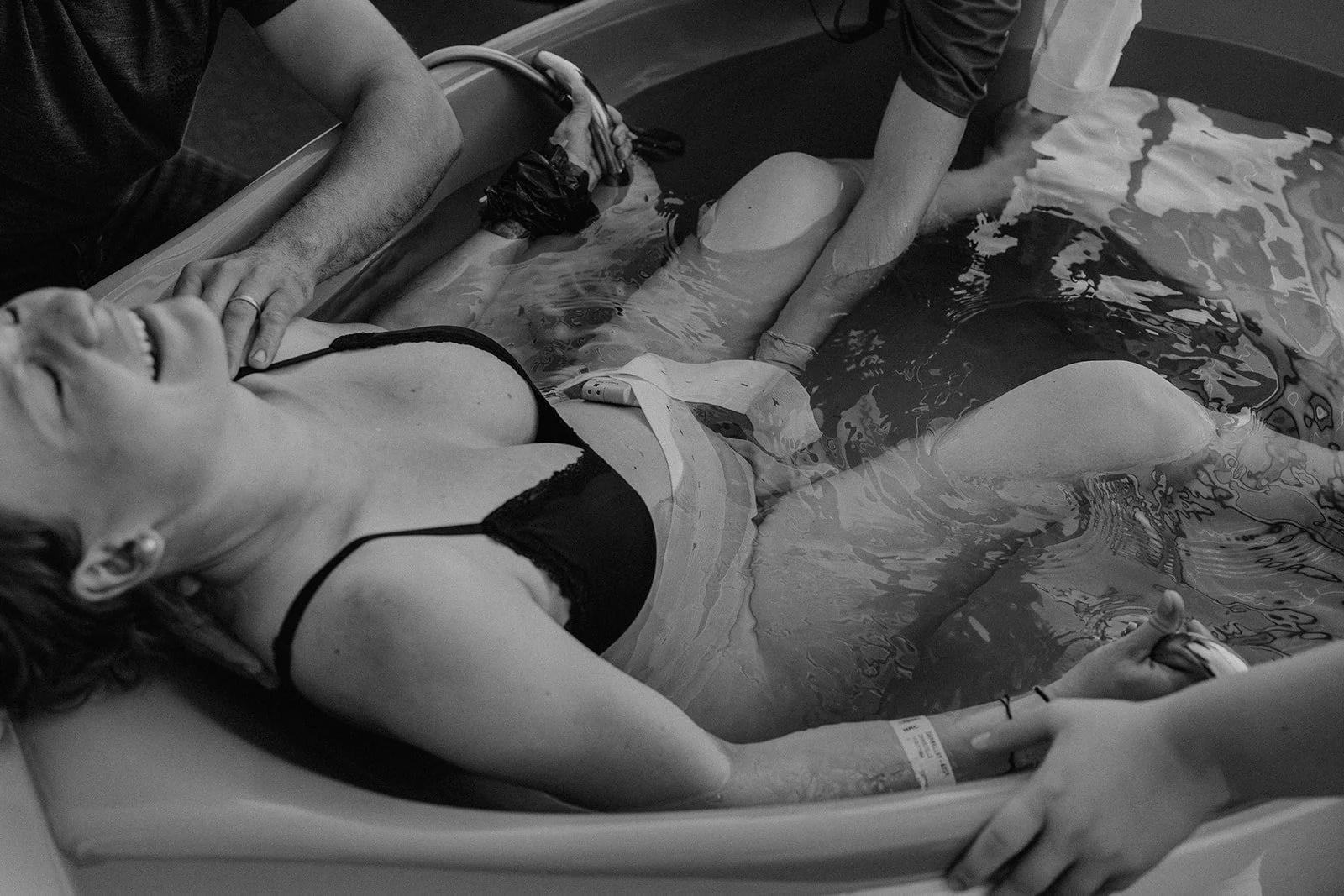 Un accouchement physiologique dans l’eau, accompagné avec douceur et respect, capturé lors d’un reportage d’accouchement en Suisse romande pour raconter la puissance de la naissance.