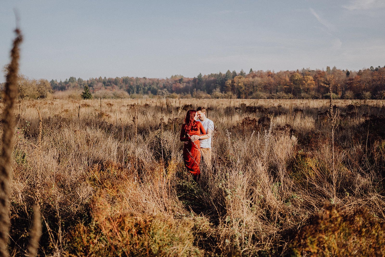 Séance photo grossesse en pleine nature : un couple se retrouve au cœur d’un champ aux couleurs d’automne, dans une atmosphère douce et intime pour célébrer l’attente de leur bébé.