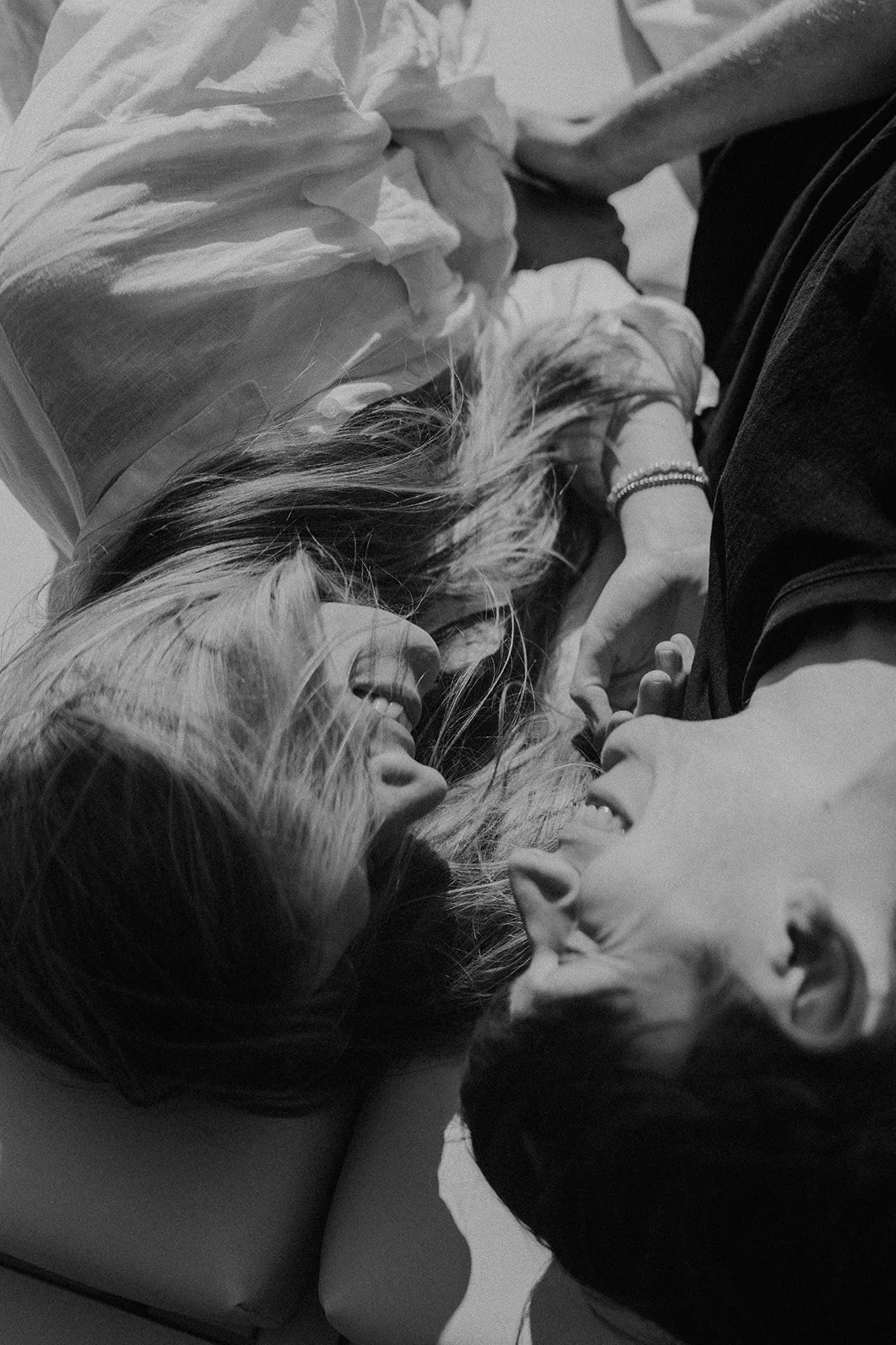 Séance couple pleine de spontanéité : un moment de rire et de complicité capturé dans une lumière douce, révélant la tendresse et la connexion entre deux amoureux.