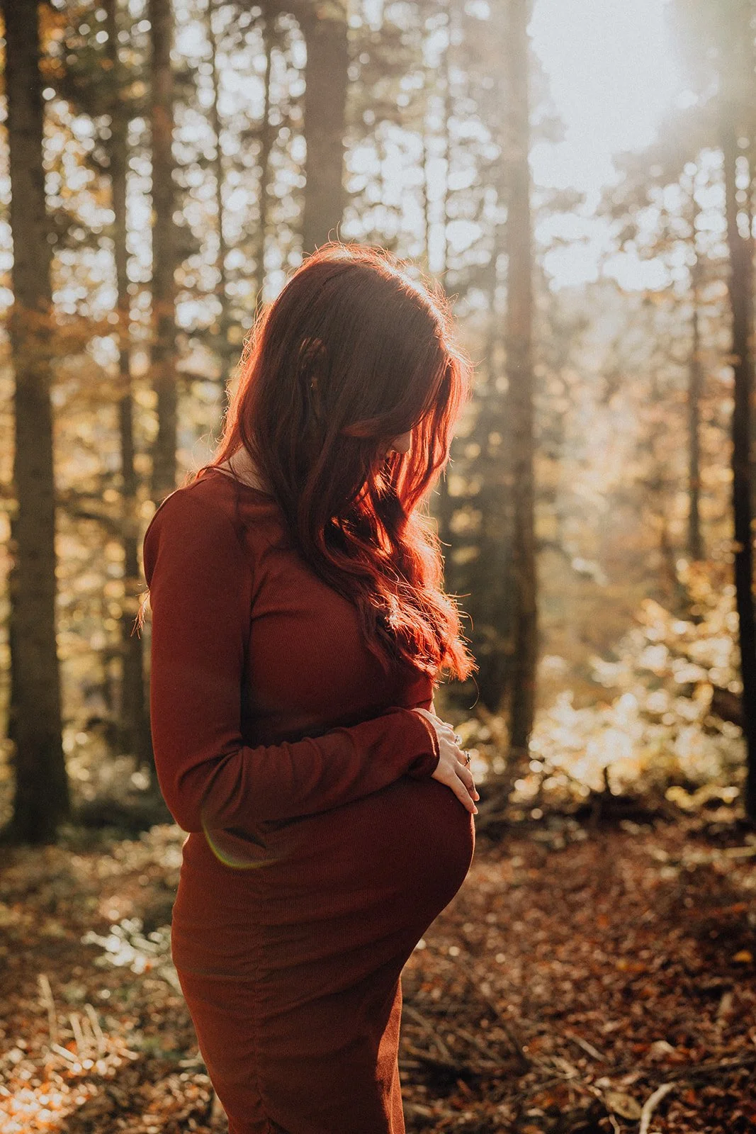 Séance photo grossesse en forêt : une future maman illumine un décor automnal baigné de lumière dorée, dans un portrait intime et poétique célébrant l’attente de son bébé.