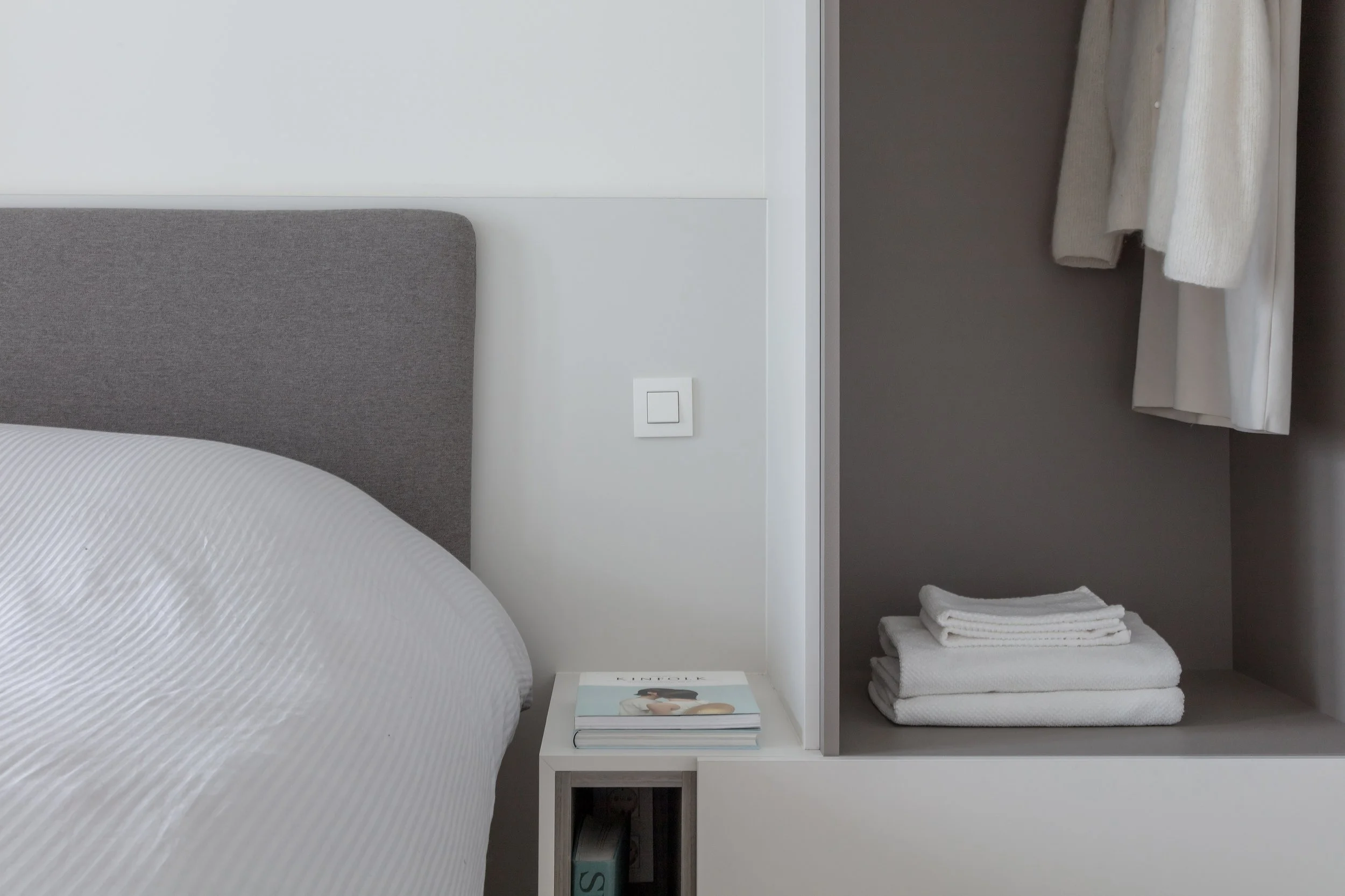 Compacte slaapkamer met maatkasten en geïntegreerde opbergruimte in vakantieappartement