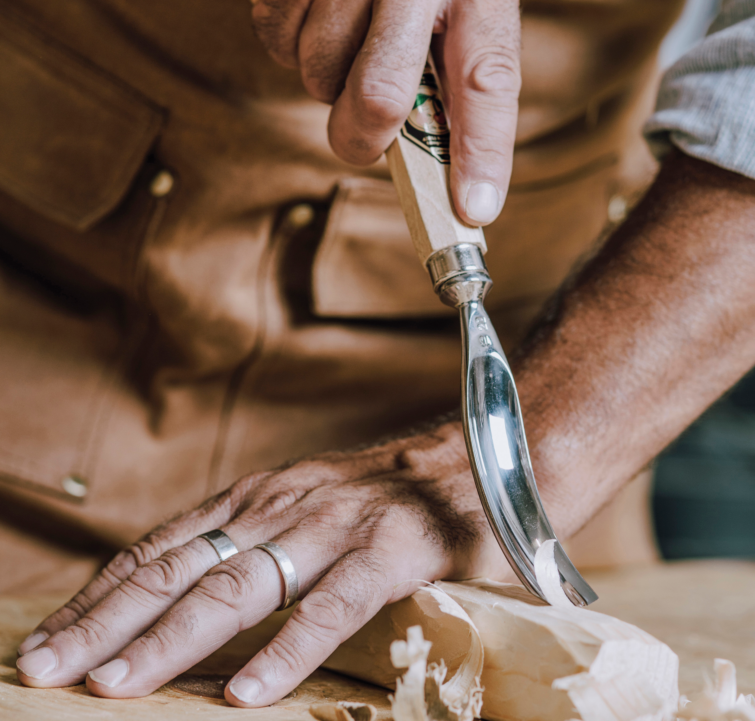 Image of Mans hands crafting project with metal scapal tool.