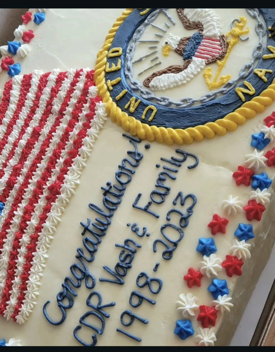 Cake decorated with American flag colors and a nautical theme, commemorating the Coast Guard's 150th anniversary with the inscription 'Congratulations CDC VASH E. Faring 1998-2023 150th' and an image of a Coast Guard emblem.