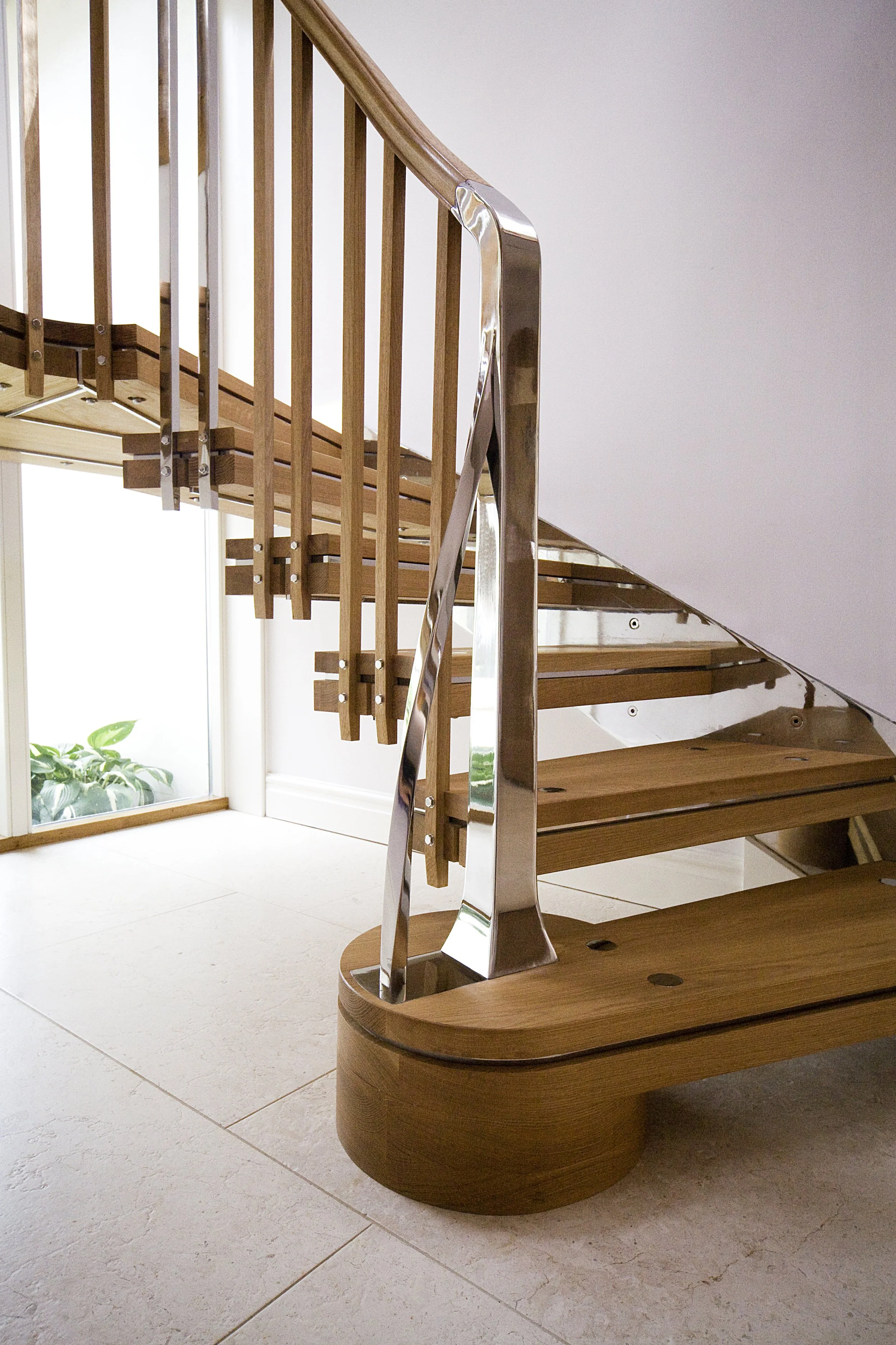 Bespoke oak and polished stainless steel cantilevered staircase in an historic cottage.