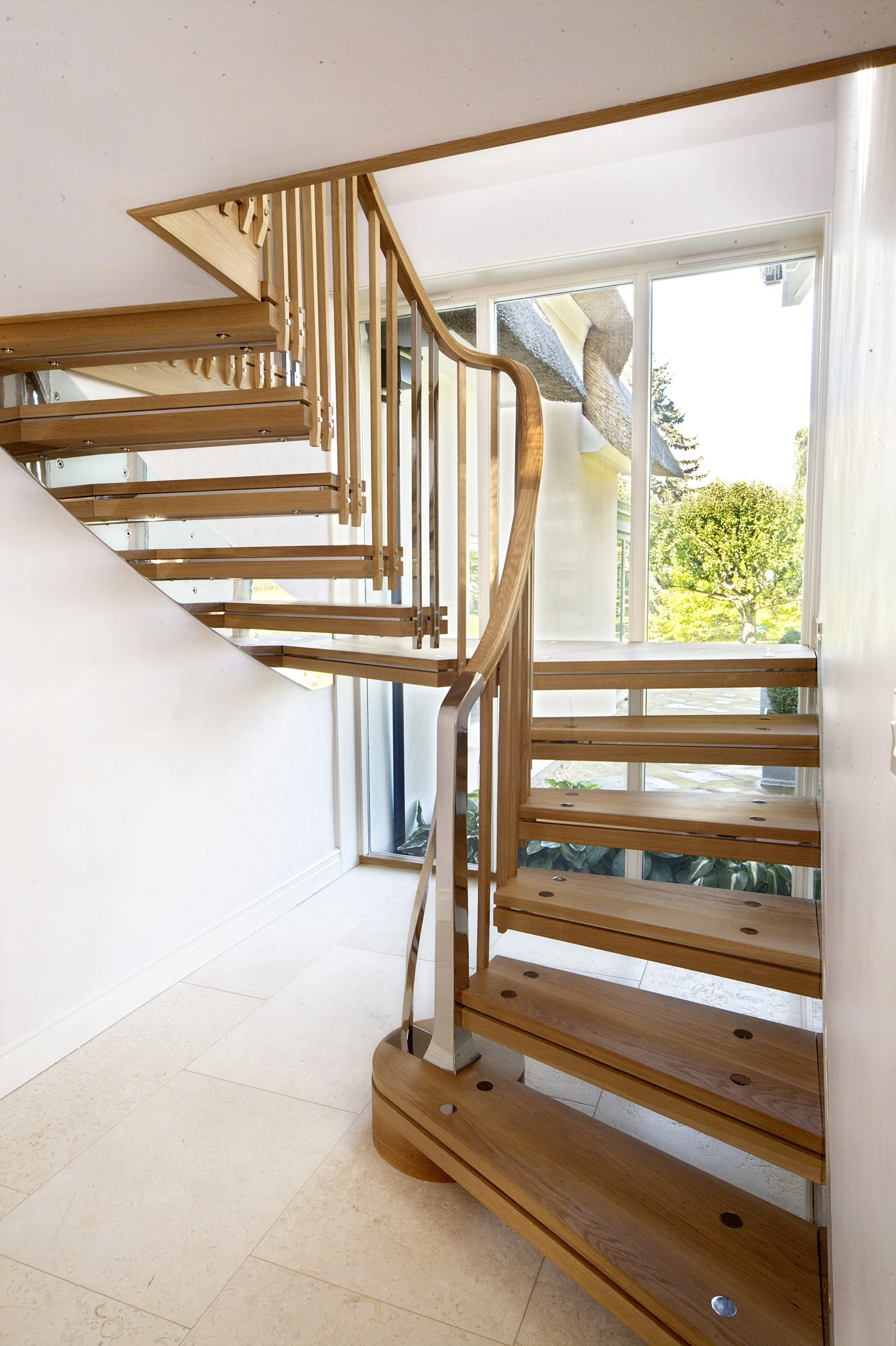 Bespoke oak and polished stainless steel cantilevered staircase in an historic cottage.