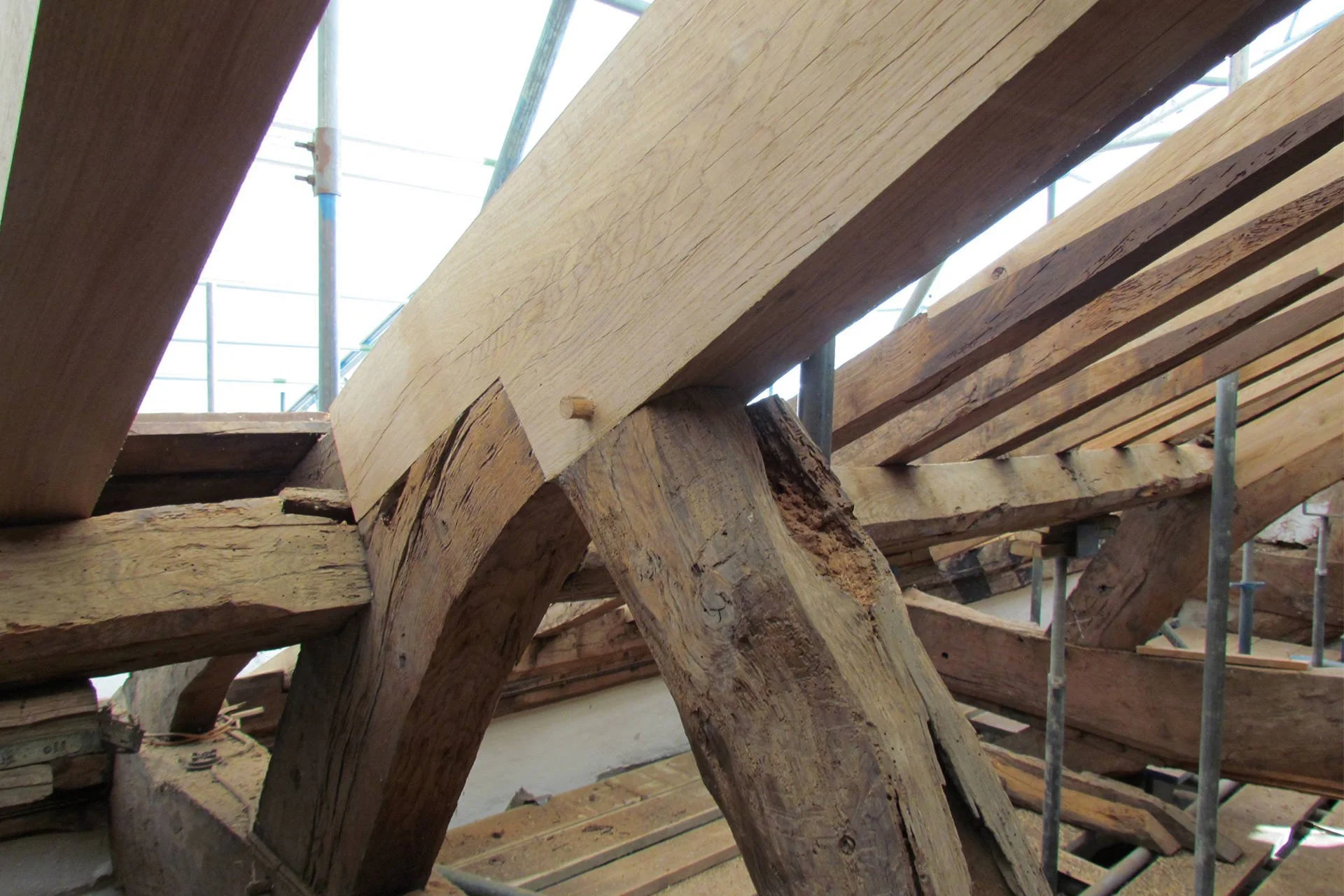 Construction site with large wooden beams and scaffolding, likely part of a building framework.