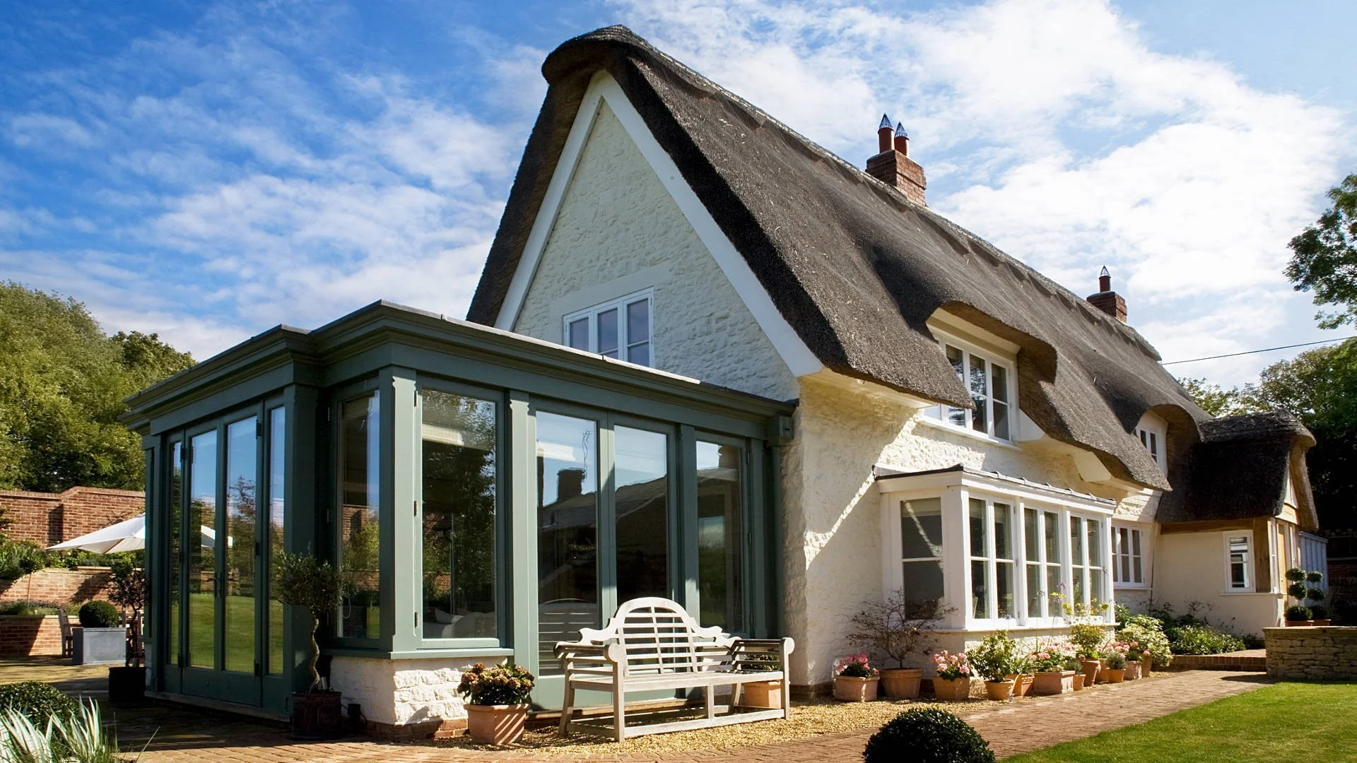 A thatched cottage with a bespoke timber-framed orangery extension.