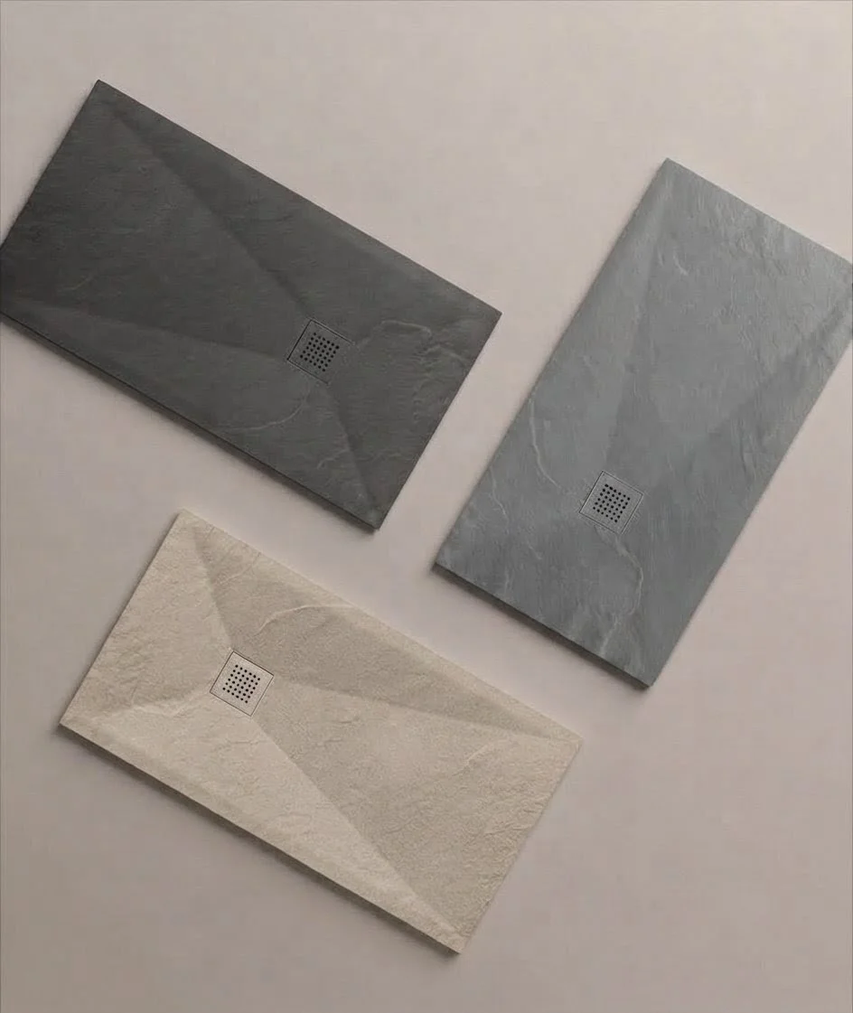 Trois carreaux en pierre naturelle de différentes couleurs et textures, disposés sur une surface blanche, avec des motifs de veines naturelles et une zone de drainage au centre.