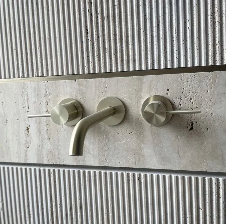 Panneau mural de douche en béton fibré strié avec robinetterie intégrée.