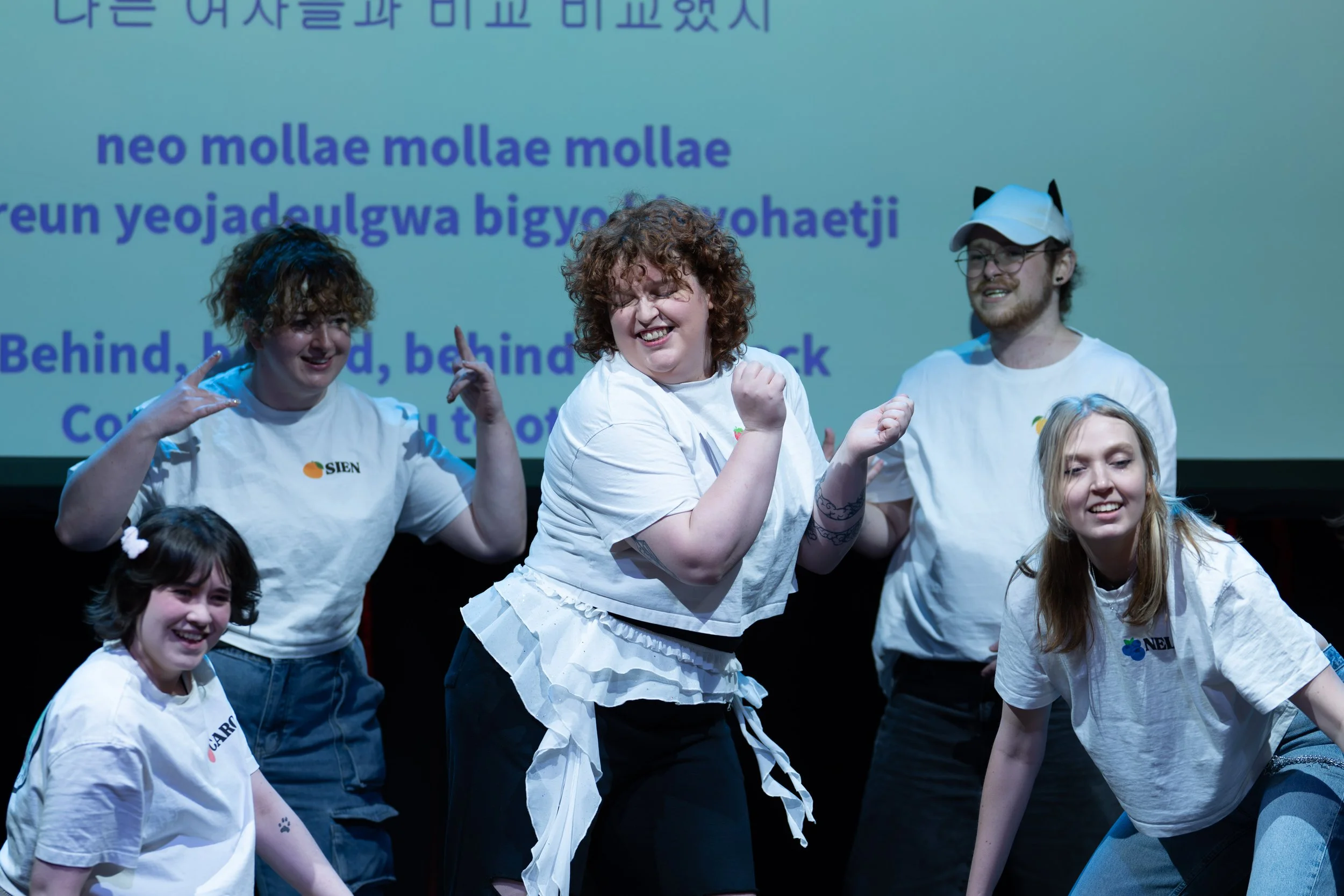 Dynamische groepsfoto van dansers die optreden tijdens een Aziatisch cultuur- of cosplay-event.