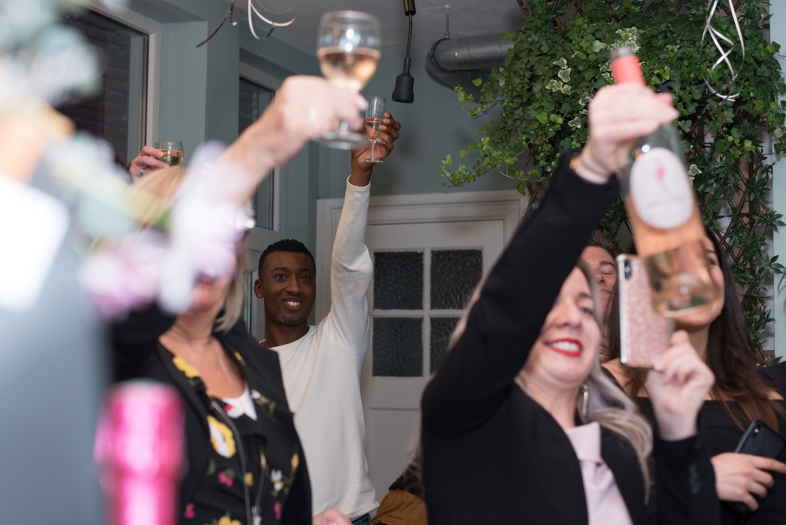 Eventfotografie van gasten die hun glazen heffen en proosten tijdens een feestelijke borrel.