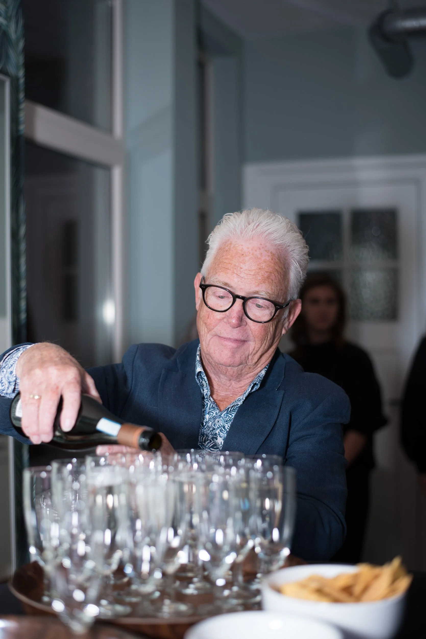 Evenementenfotografie van een man in pak die drank inschenkt tijdens een formele receptie.