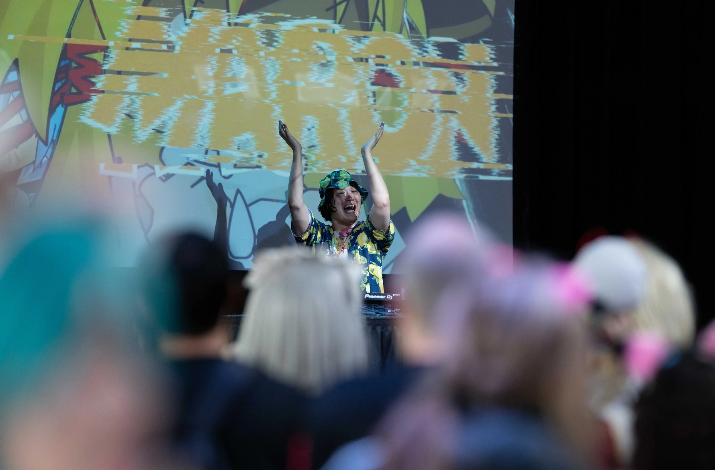 Eventfotografie van een DJ die optreedt voor een publiek tijdens een feest of zakelijk evenement.