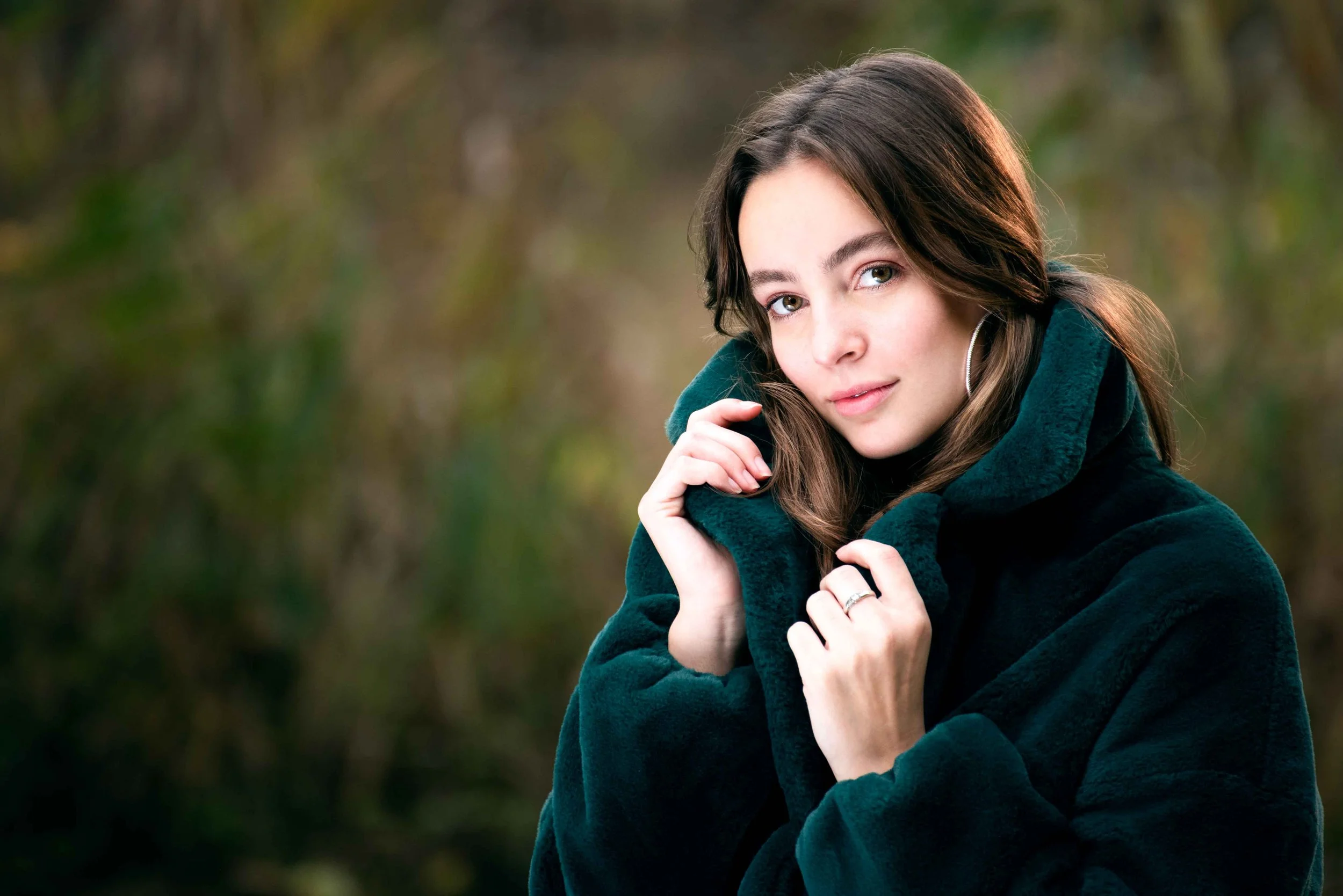 Portretfotografie Rotterdam door Eeden Photography: buitenportret van een jonge vrouw met een groene jas.