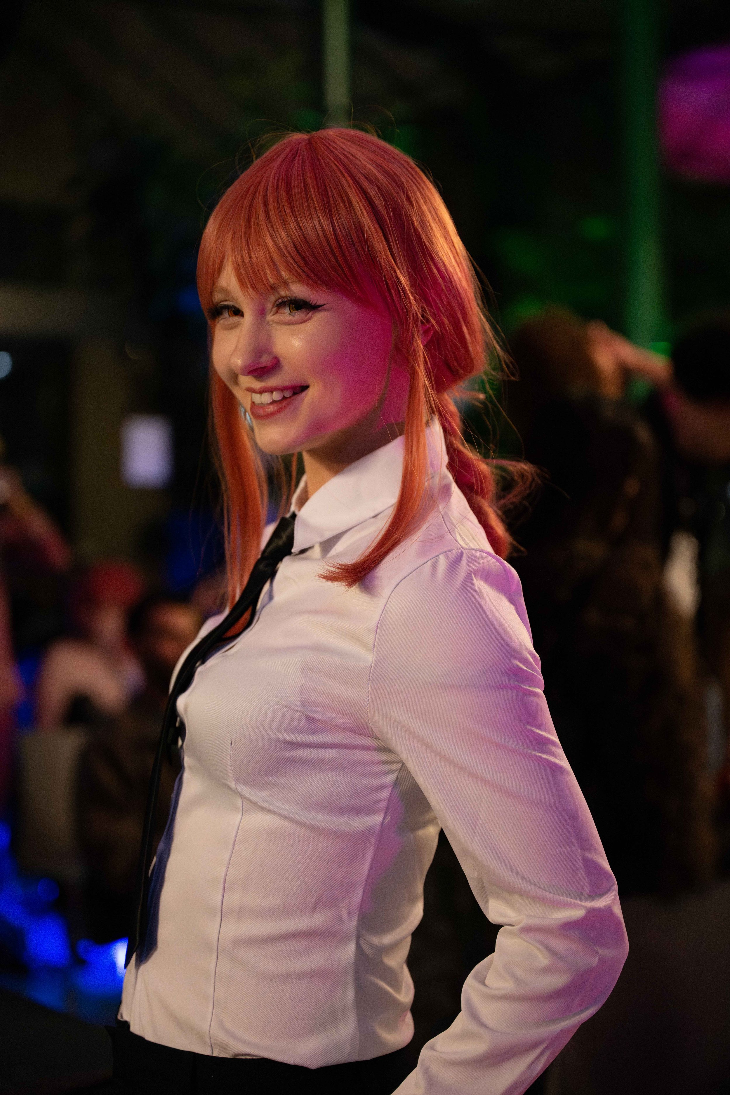 Portret van een roodharige vrouw in cosplay uniform tijdens een evenement of conventie.