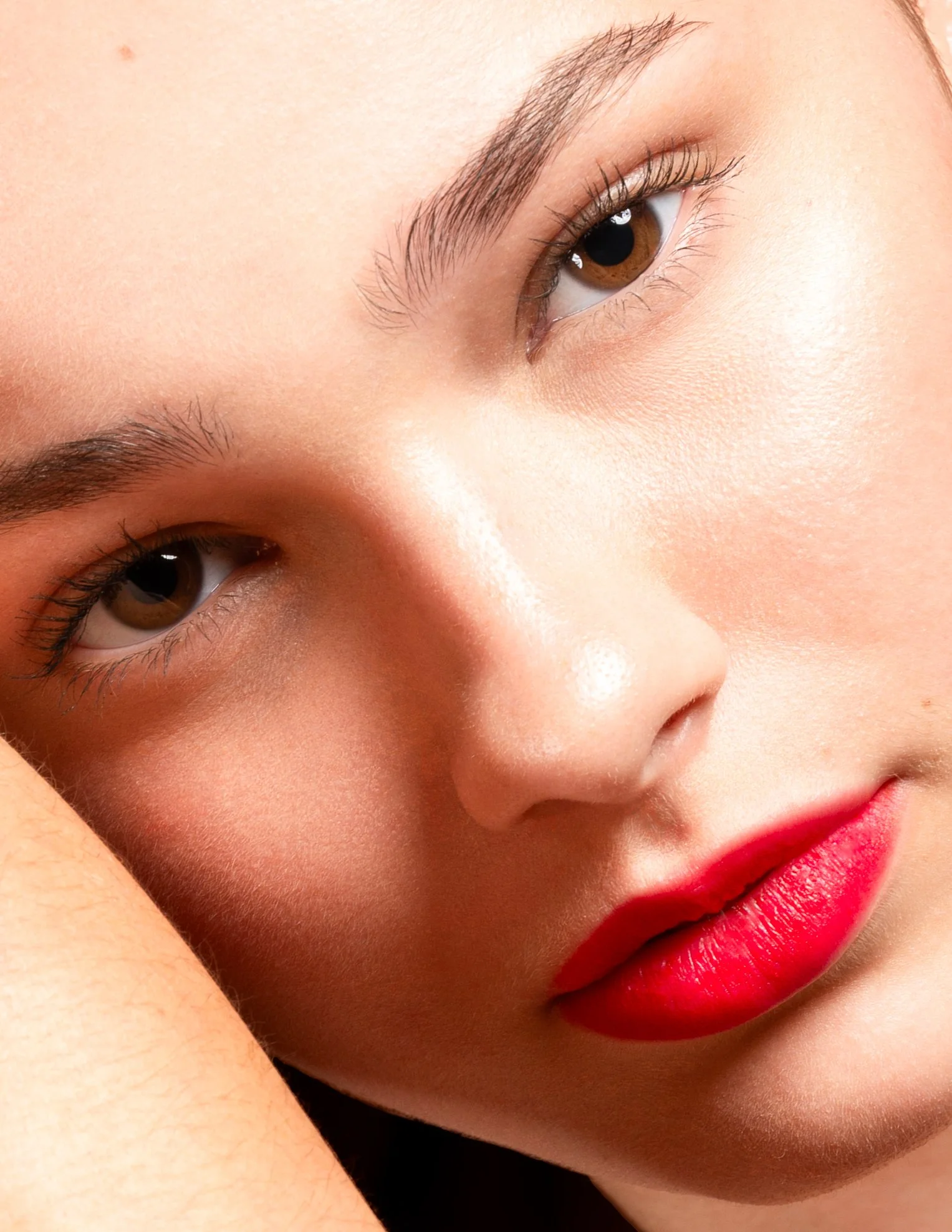 Artistieke close-up van het gezicht van een jonge vrouw met felrode lippenstift.