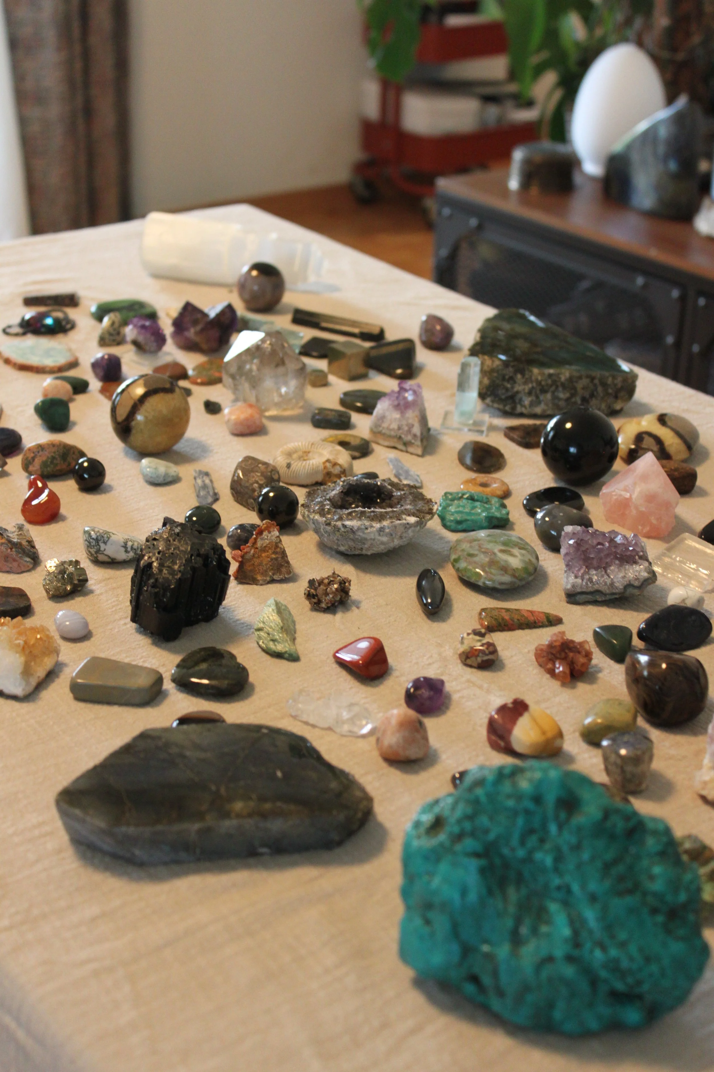 Verschiedene Mineralien und Gesteine auf einem Tuch, mit einem größeren türkisfarbenen Mineral im Vordergrund.