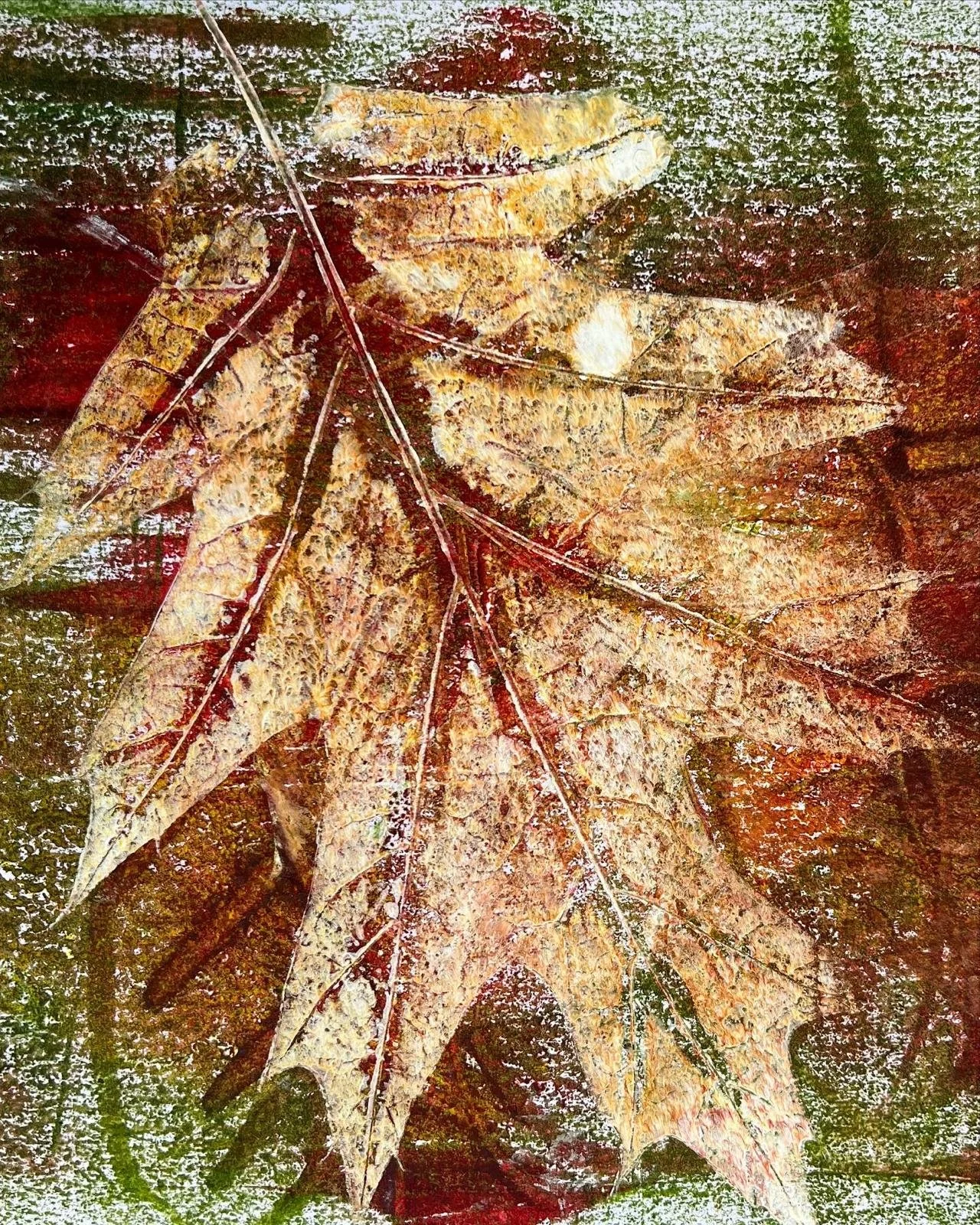 Close-up of fallen autumn leaves in shades of yellow, orange, and brown on a wet ground.