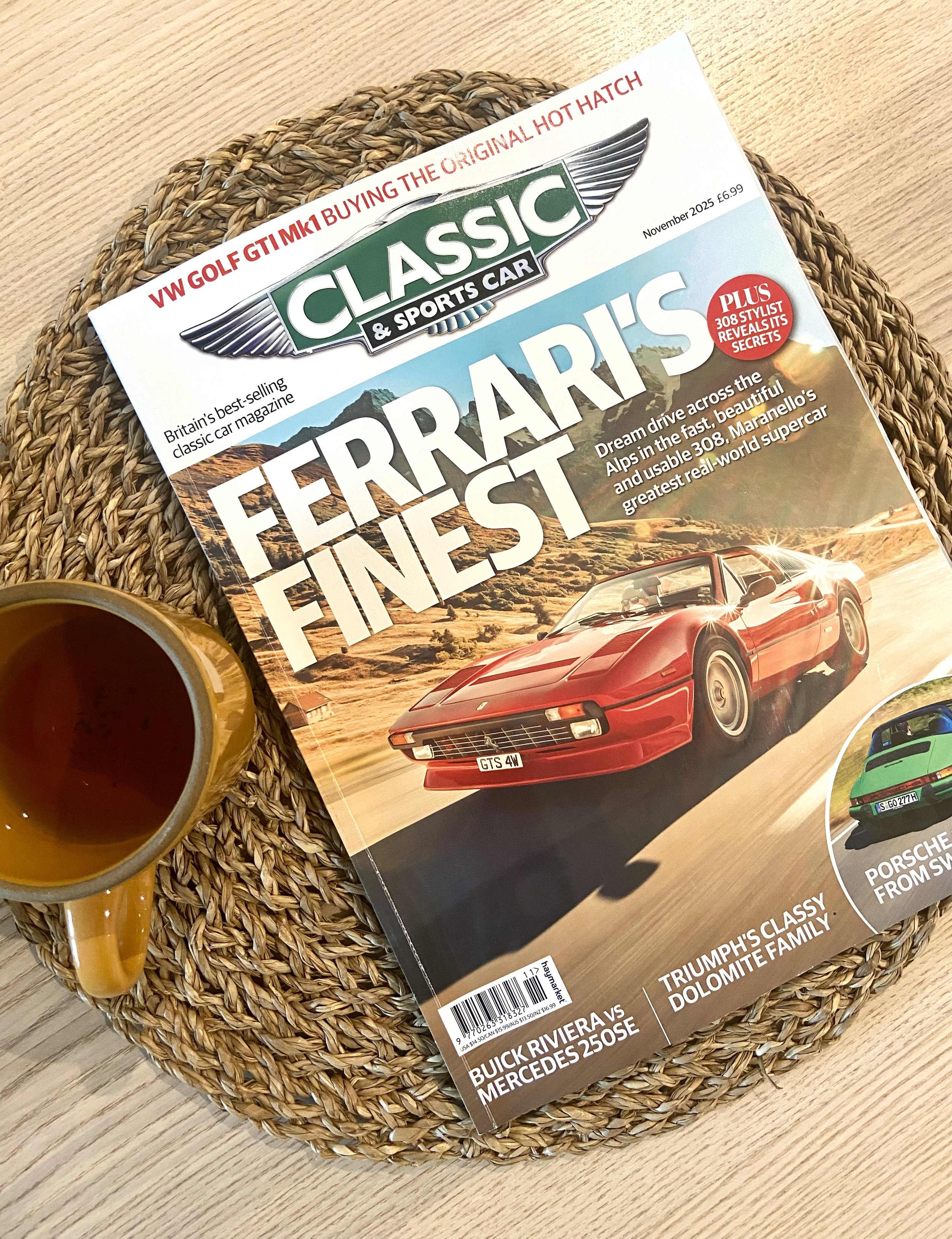A magazine titled 'Classic & Sports Car' on a woven placemat, with a yellow coffee mug partially visible to the left.