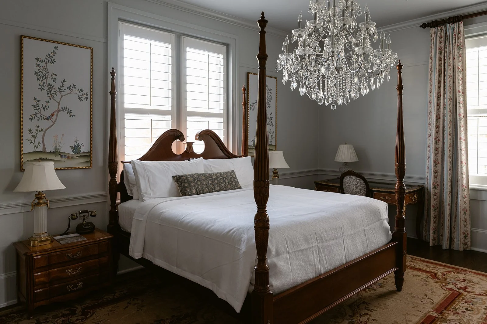 A luxurious bedroom with a four-poster bed, white bedding, and pillows, illuminated by natural light. Hotel Everett | Boutique Hotel in Winnsboro, SC, historic hotel
