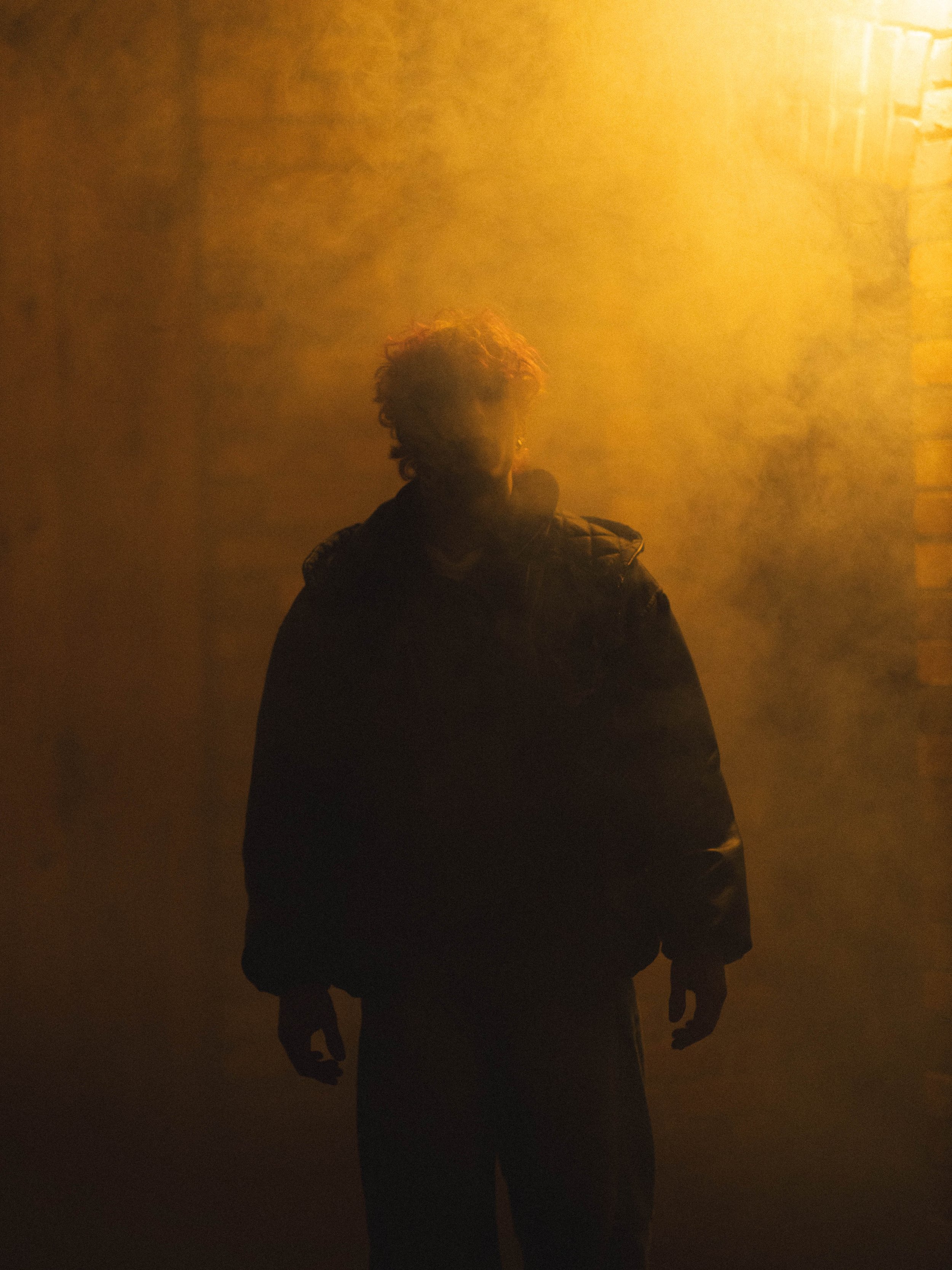 Ein Mann steht cool im Nebel und man sieht nur seine Silhouette.  