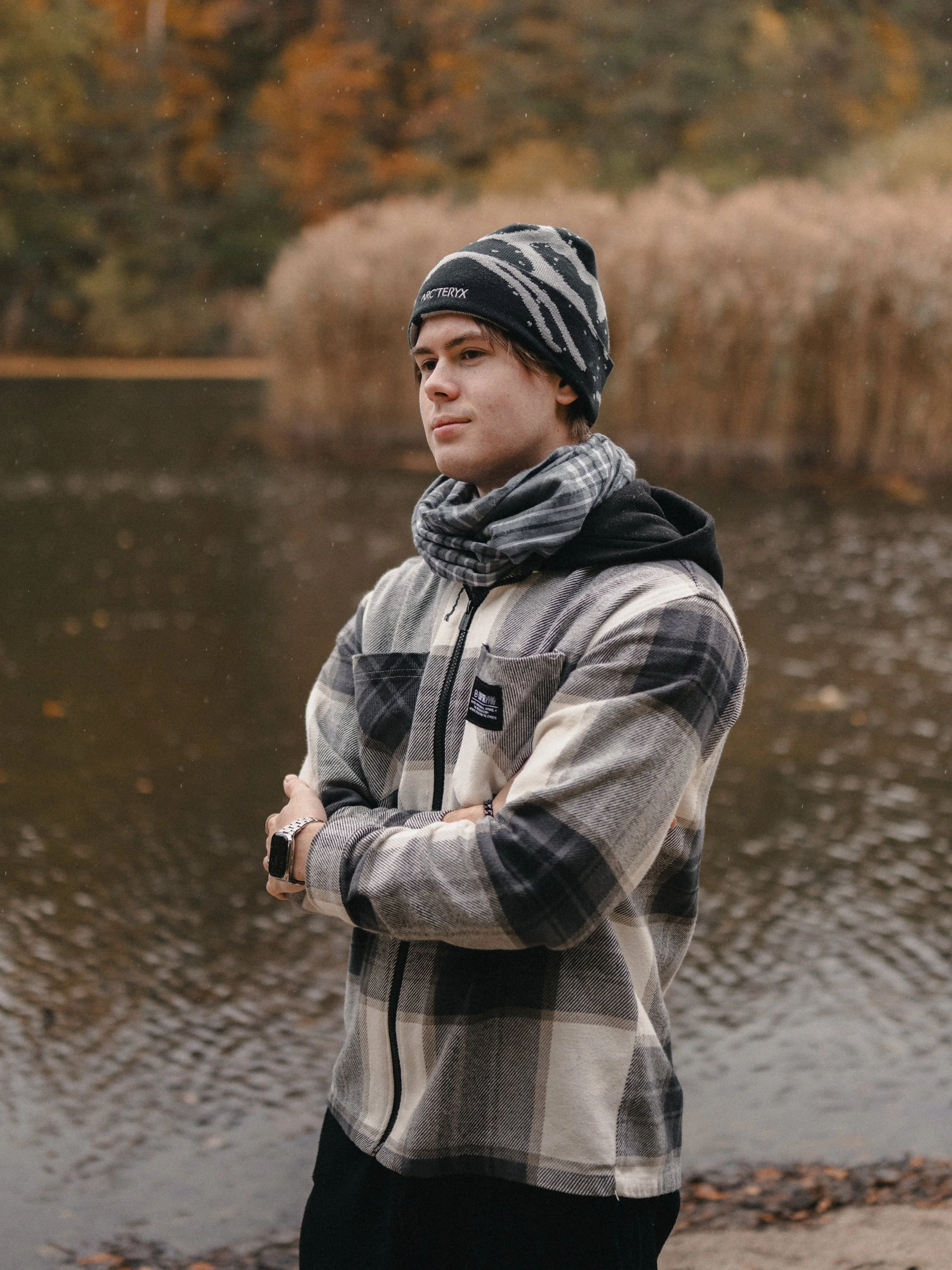 Fotograf Florian Herold im herbstlichen Wald, trägt karierte Jacke und Apple Watch und Arcteryx Mütze