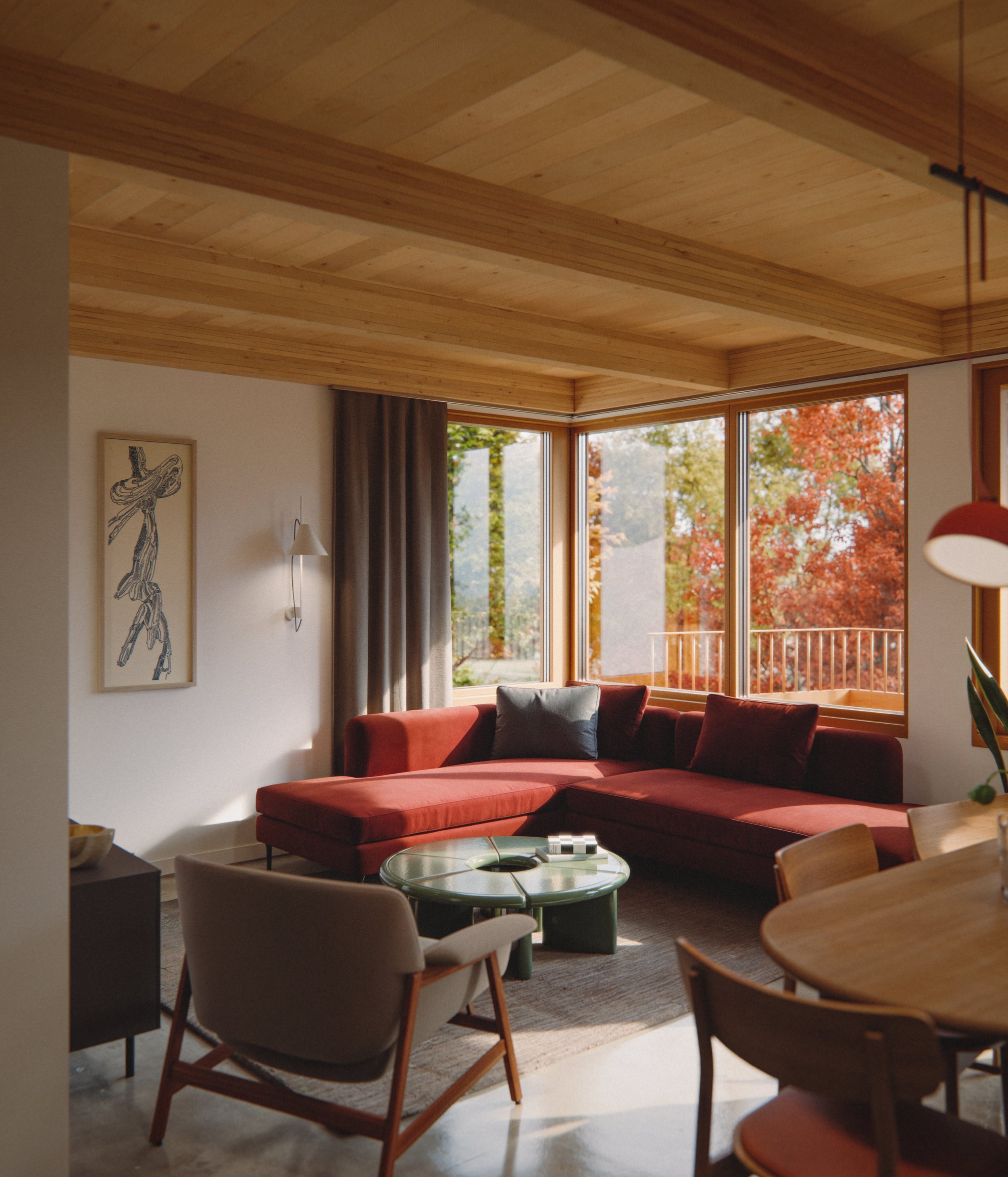 Cozy living room with large windows, mass timber exposed ceiling, a red sectional sofa, a round green coffee table, modern chairs, and autumn trees outside.