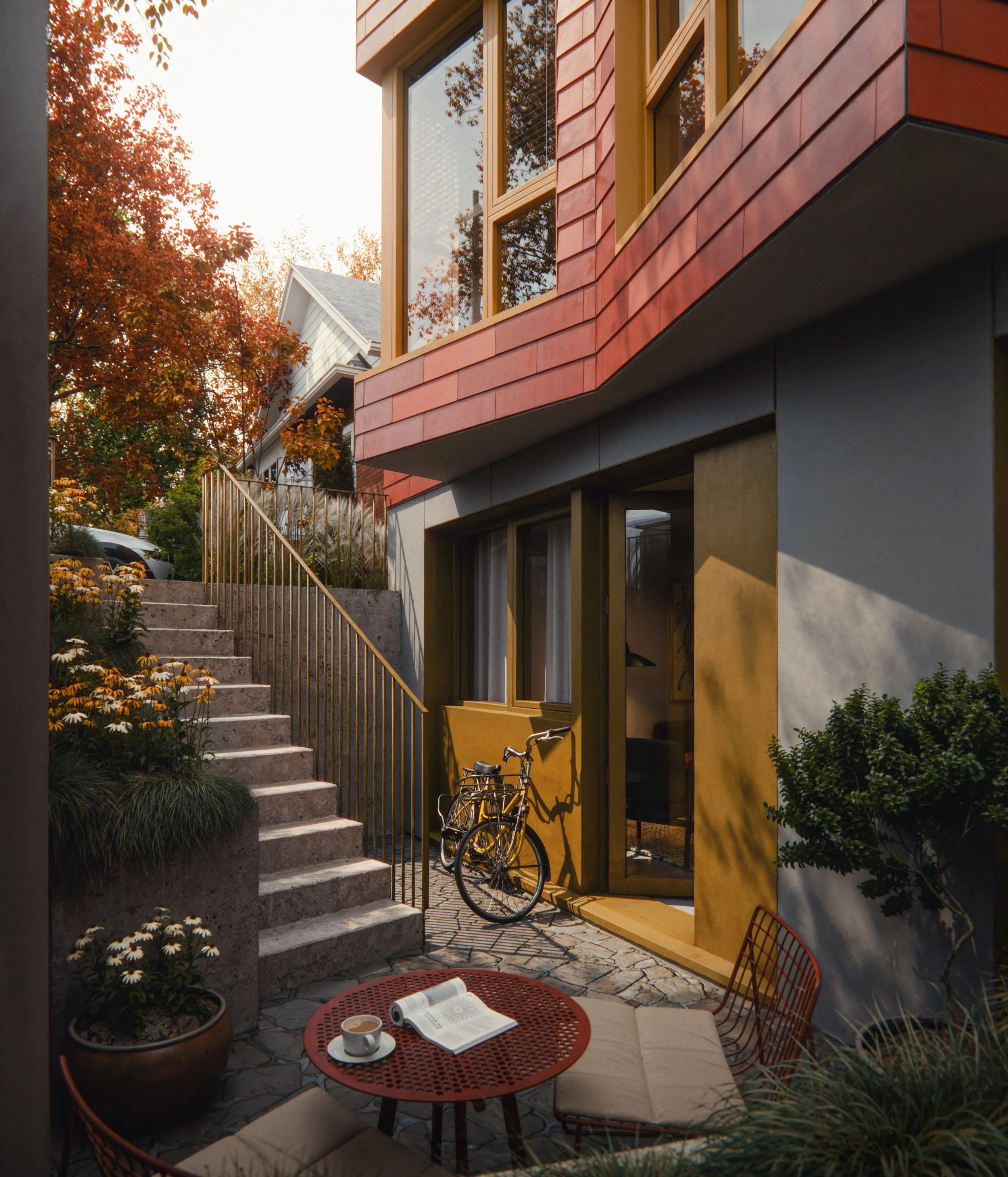 An outdoor patio area with a small round table, a book, a coffee cup, and four cushioned chairs. A bicycle is parked against the house wall. Wooden stairs with a metal railing lead up to another level. The house has large windows, colorful exterior walls, and is surrounded by plants and trees with autumn foliage.