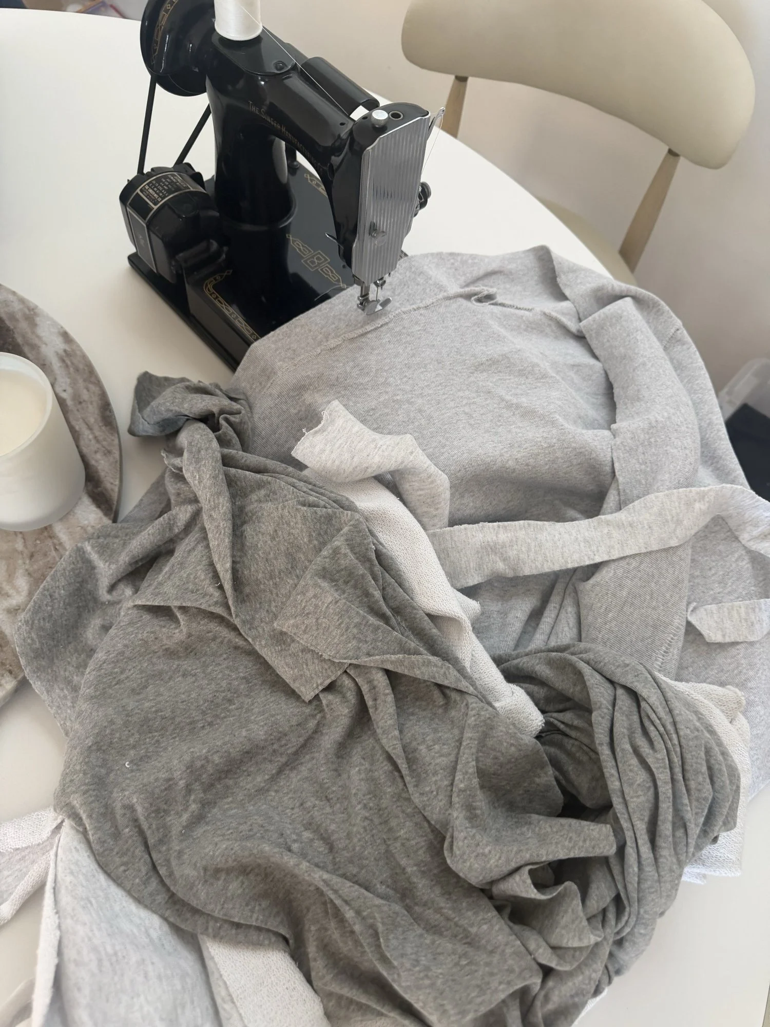 A sewing machine beside a pile of reclaimed fabric