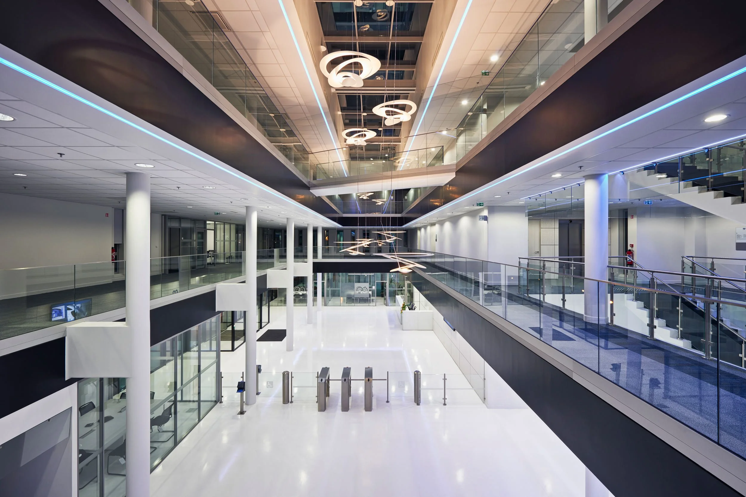 Ungrand hall moderne avec des accents de bleu et des plafonds suspendus avec des lampes design