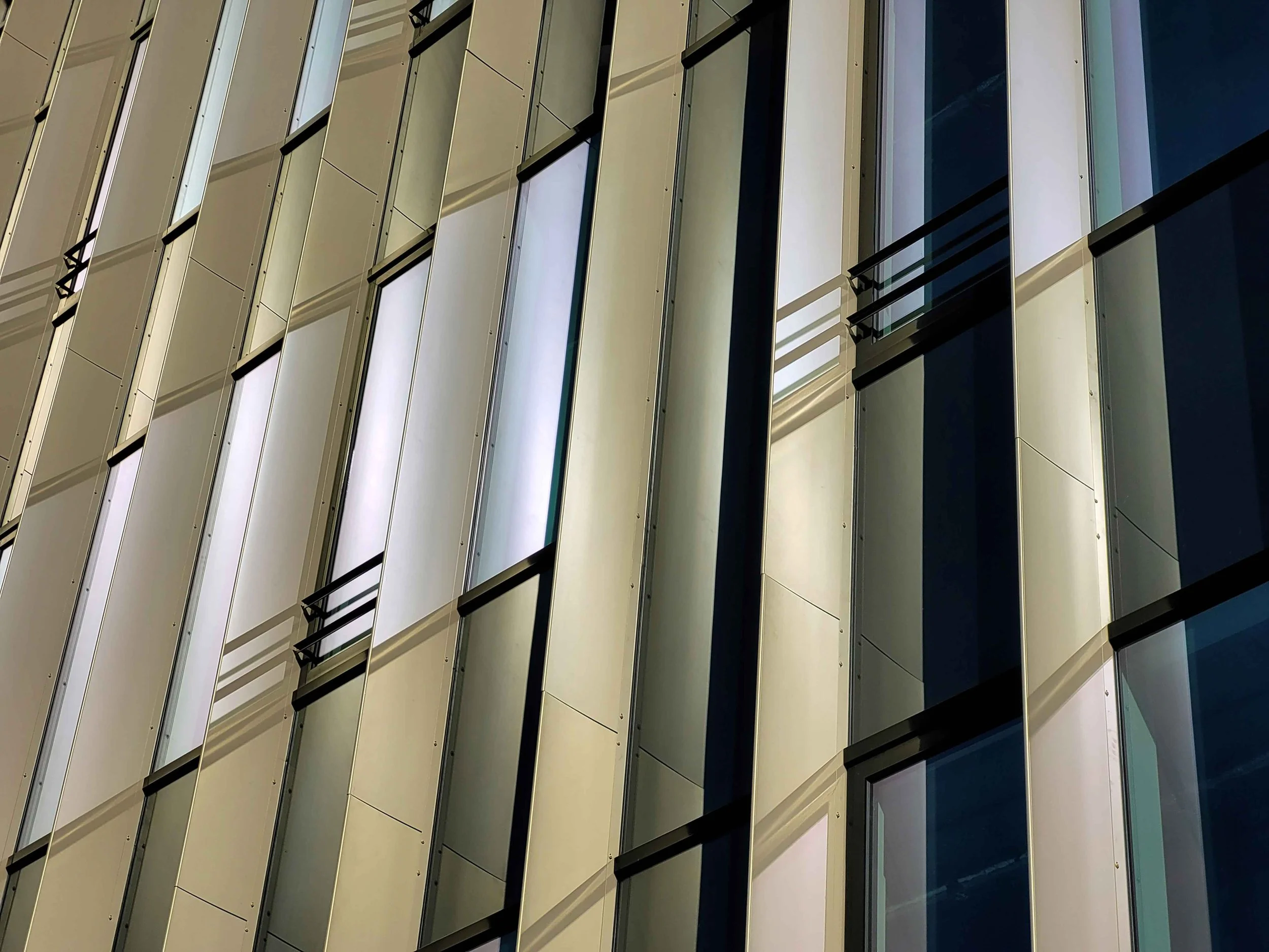 Façade moderne de bâtiment avec fenêtres en verre et balcons en aluminium, vue en angle