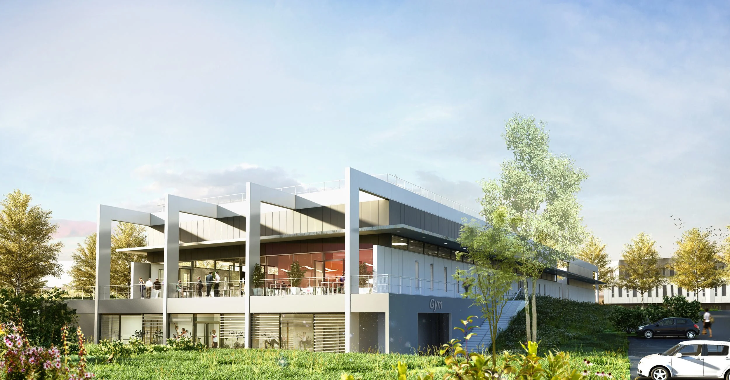Bâtiment moderne avec un gymnase, de grandes fenêtres, un parking et des personnes en extérieur, entouré d'arbres et d'herbe vernie.