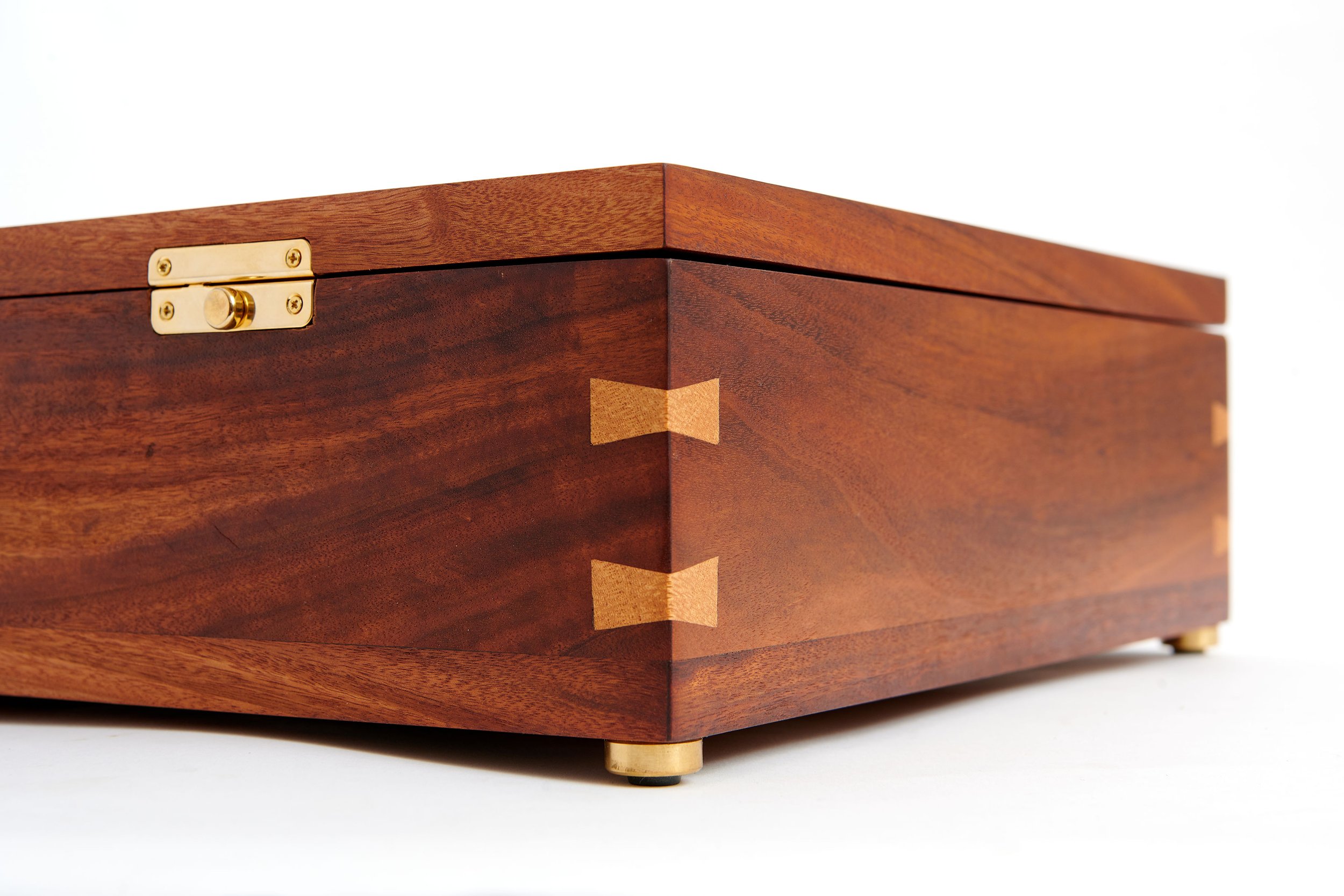Close-up of a wooden toolbox with dovetail joints and a brass hinge.
