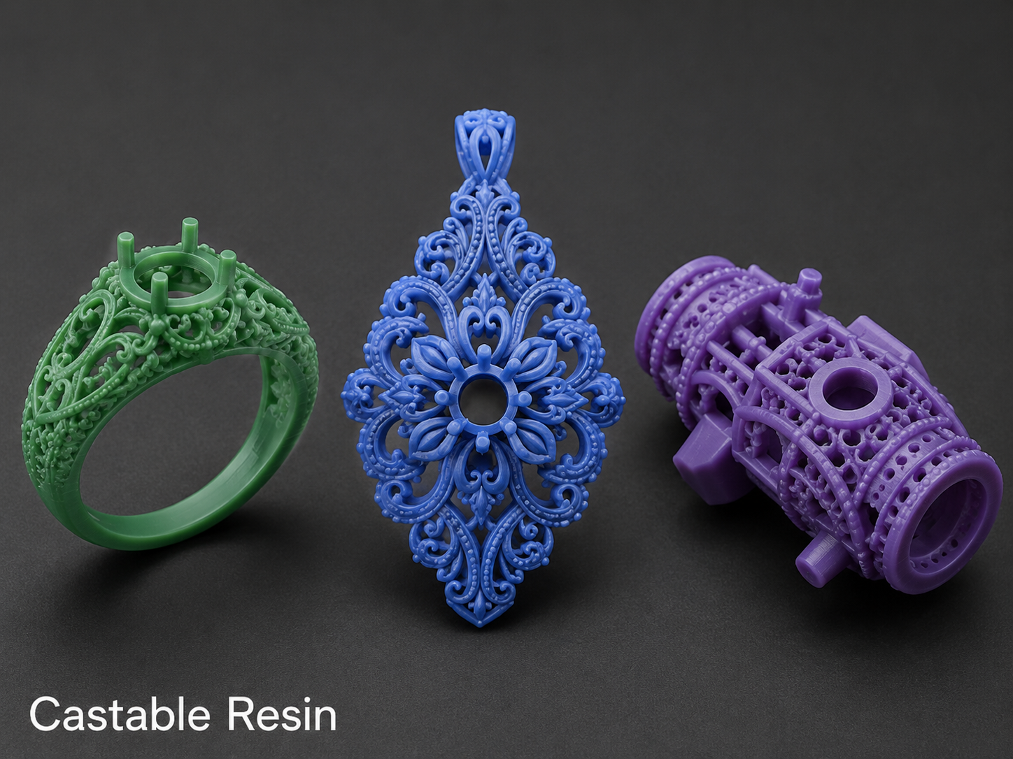 Three 3D-printed castable resin objects in green, blue, and purple, showcasing intricate lace-like and lattice patterns, set against a black background.