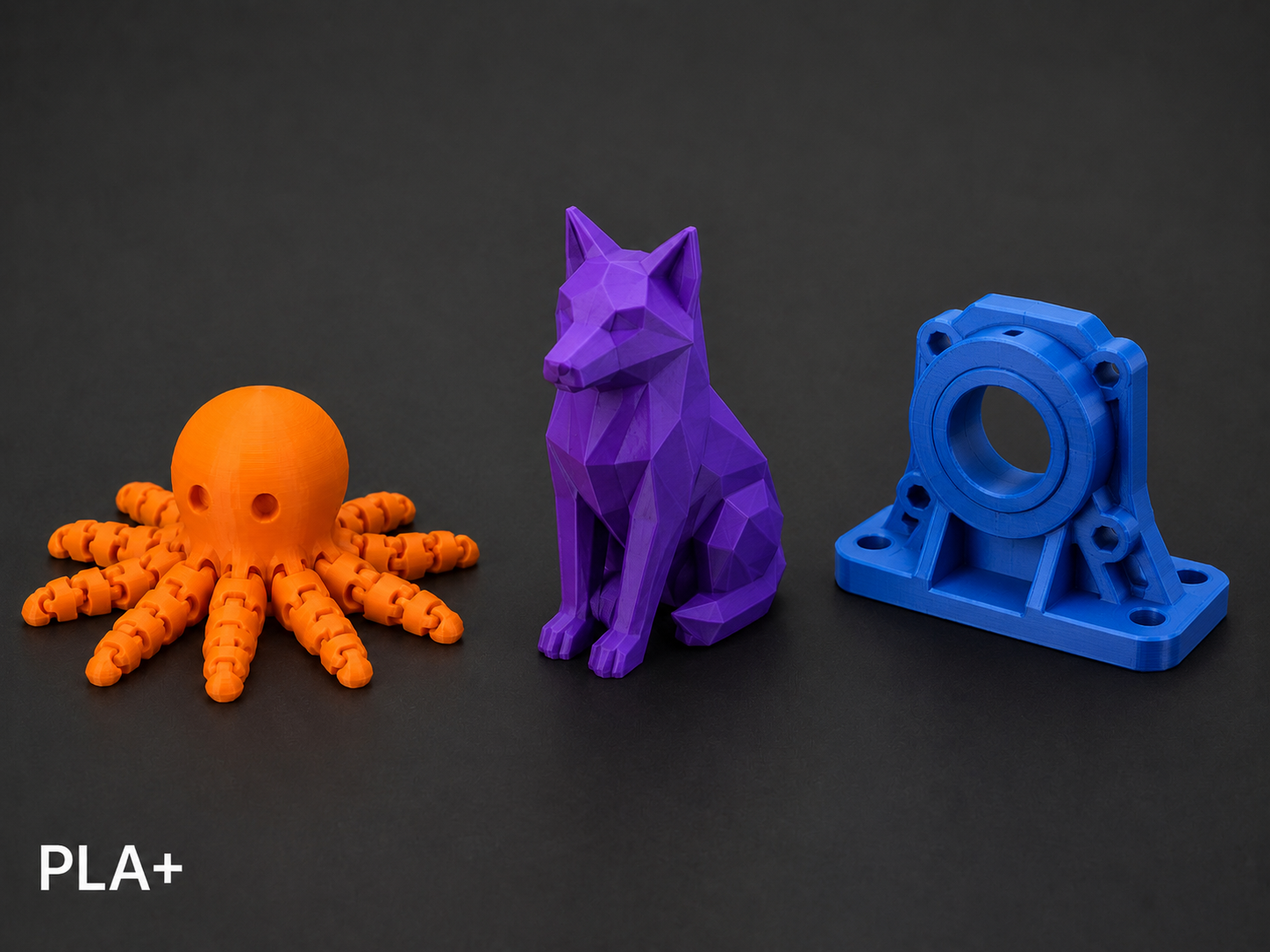 Three 3D-printed objects on a black background: an orange octopus with a hollow head and multiple limbs, a purple geometric dog model sitting upright, and a blue mechanical part with a circular opening and mounting holes.
