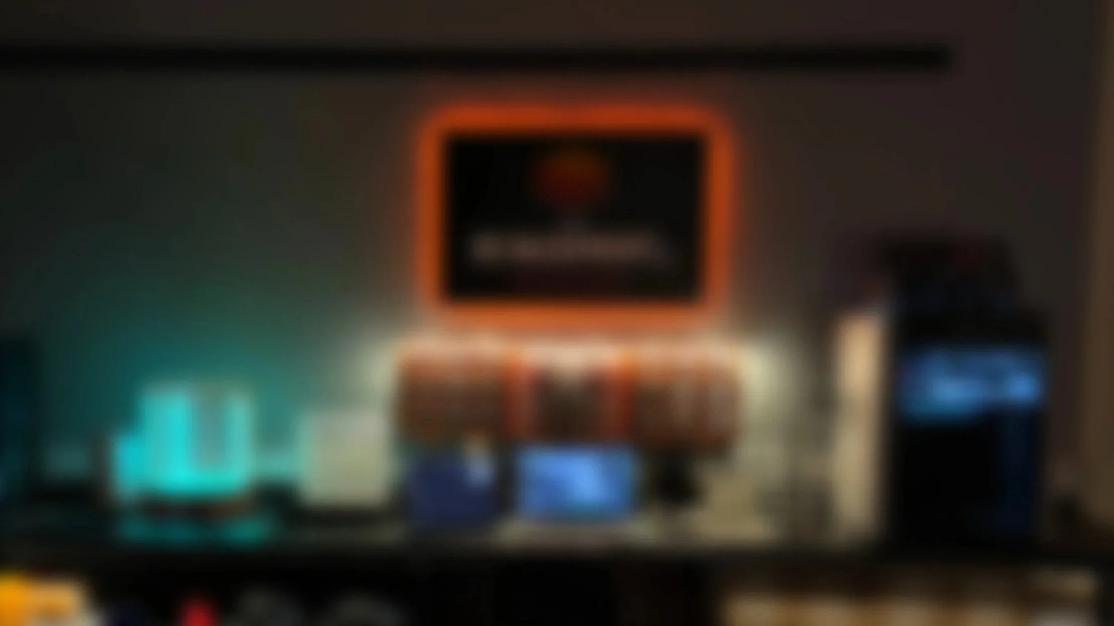 The image is blurry and unclear, presenting a dark indoor scene with some illuminated screens and a central display that appears to be a warning or informational sign, possibly in a public or technical setting.