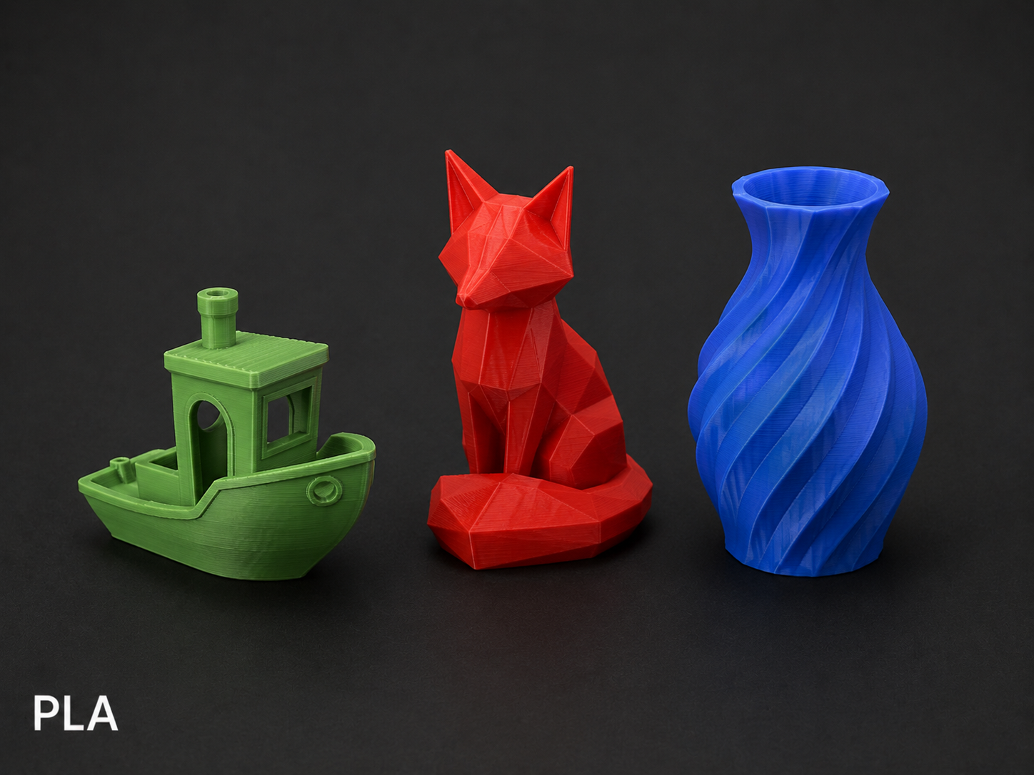 Three 3D printed objects on a black background: a green boat, a red sitting fox, and a blue spiral vase.