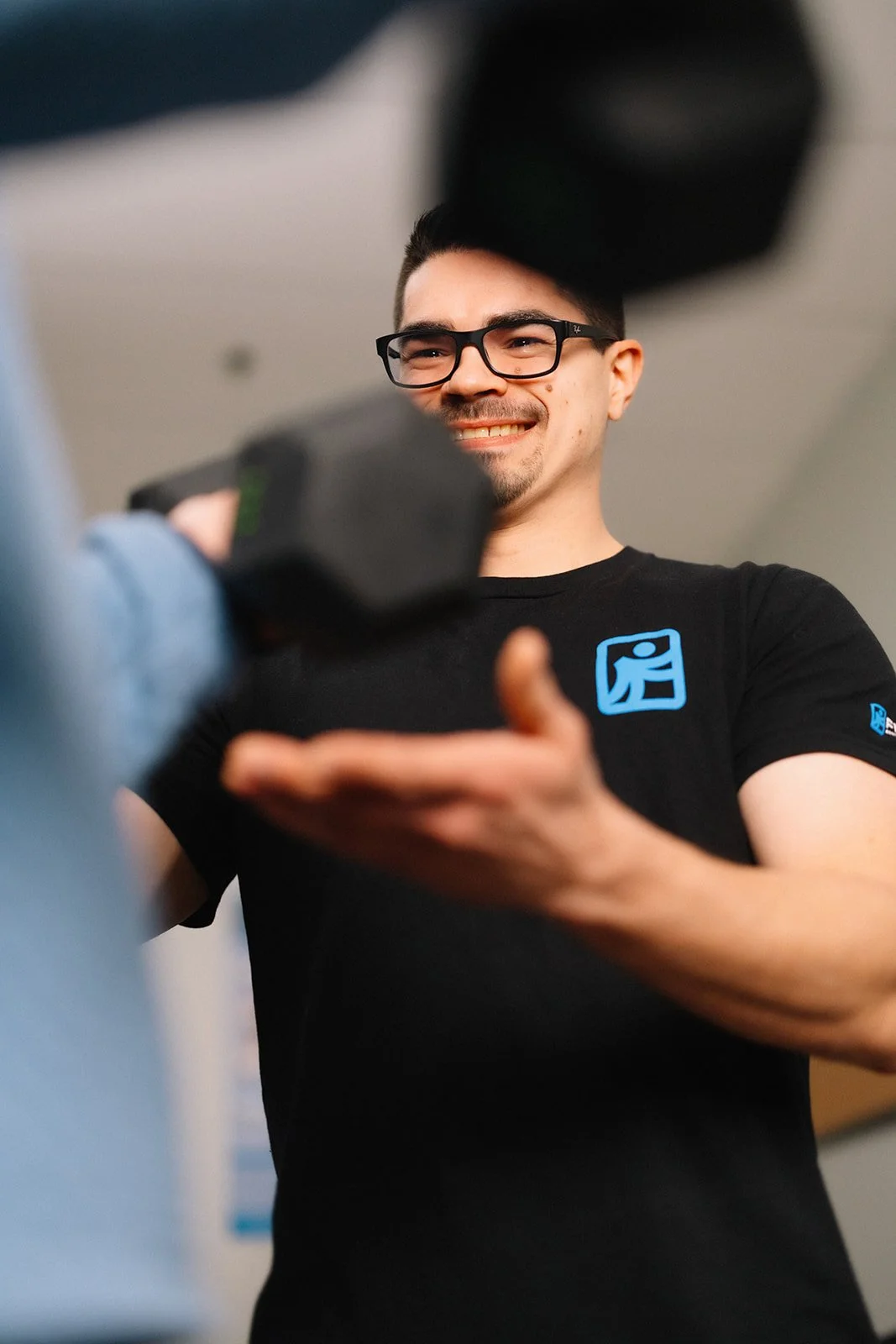 A man with glasses smiling and training a main in the sober house