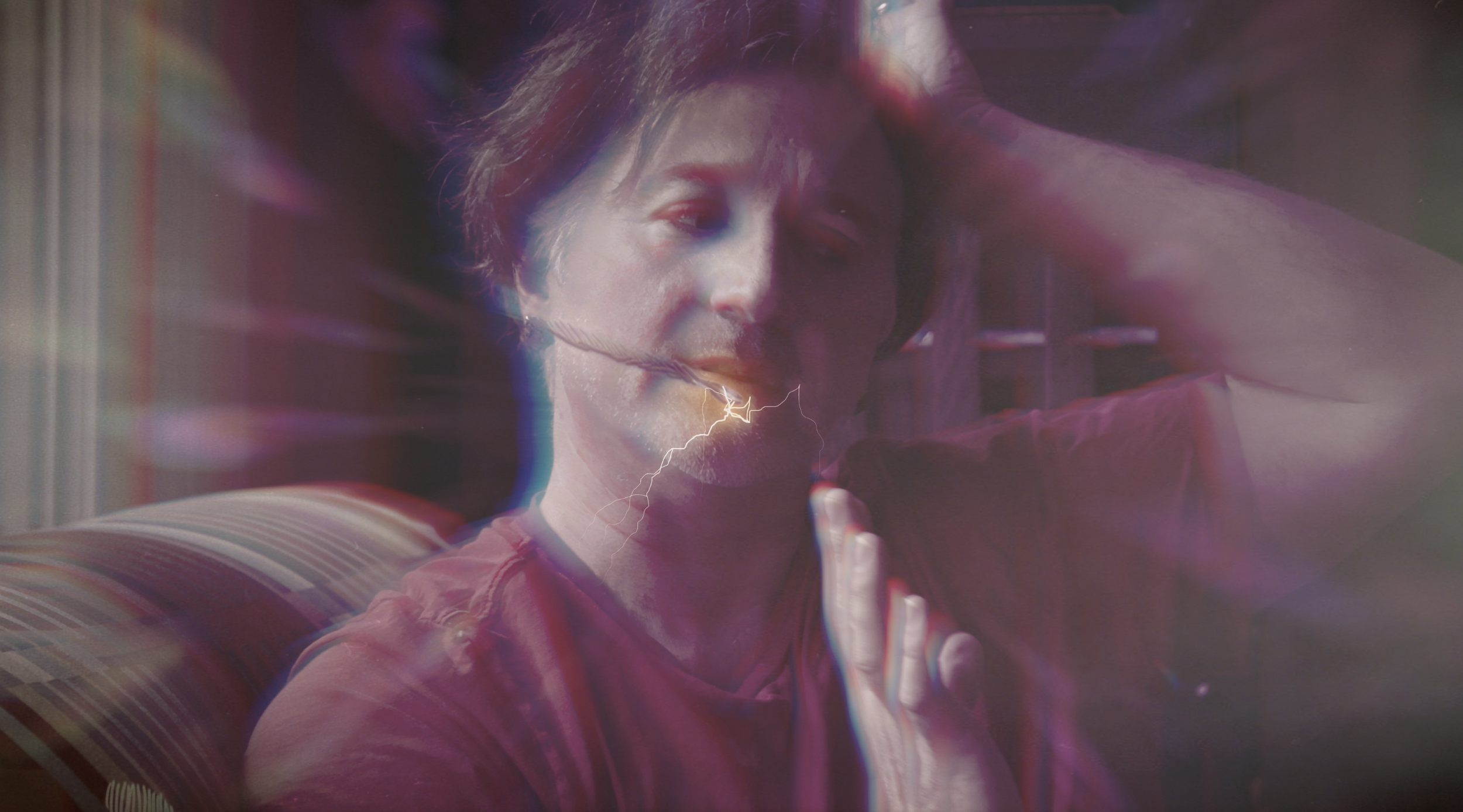 A person holding their head with one hand, with visual effects of lightning and colorful streaks overlaying the image.