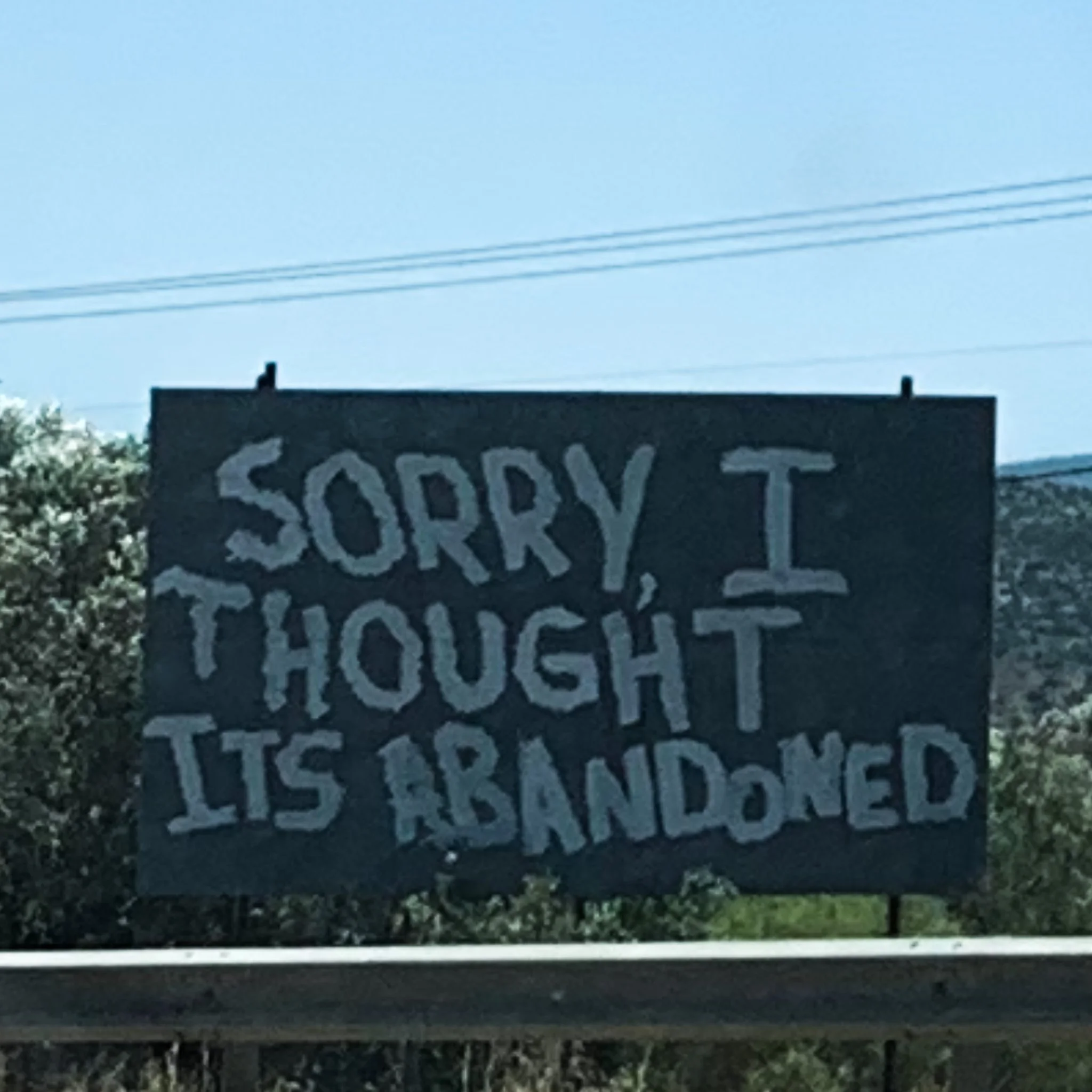 Hand‑painted roadside sign near Nemea reading “Sorry I thought its Abandoned.”