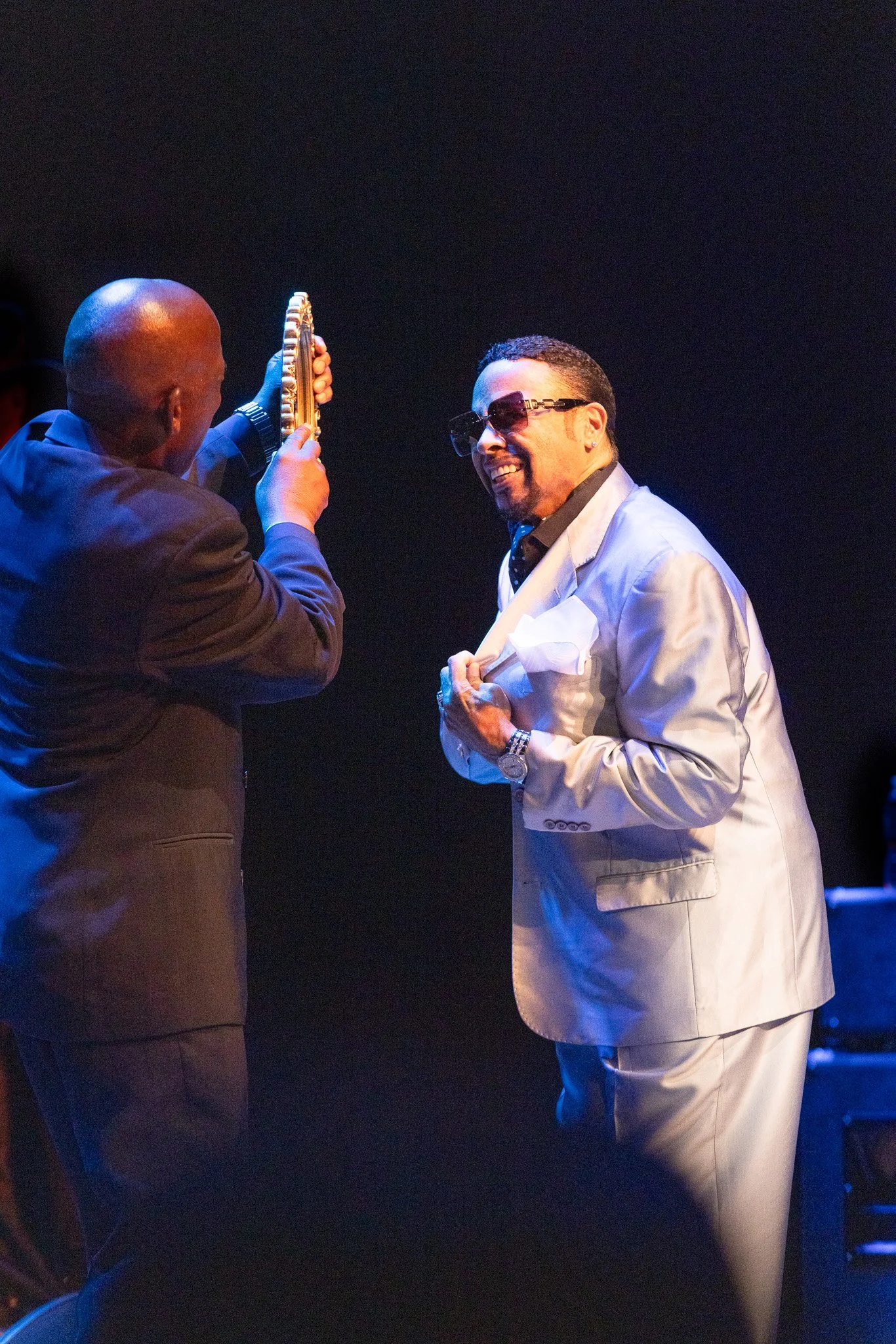 Morris Day smiling while checking his mirror onstage at Clowes Memorial Hall.