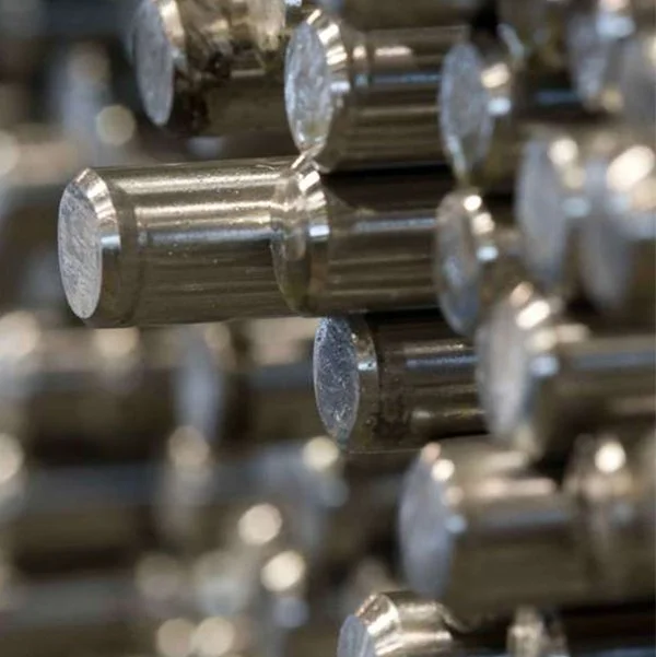 Tiges métalliques empilées dans une usine ou un entrepôt.