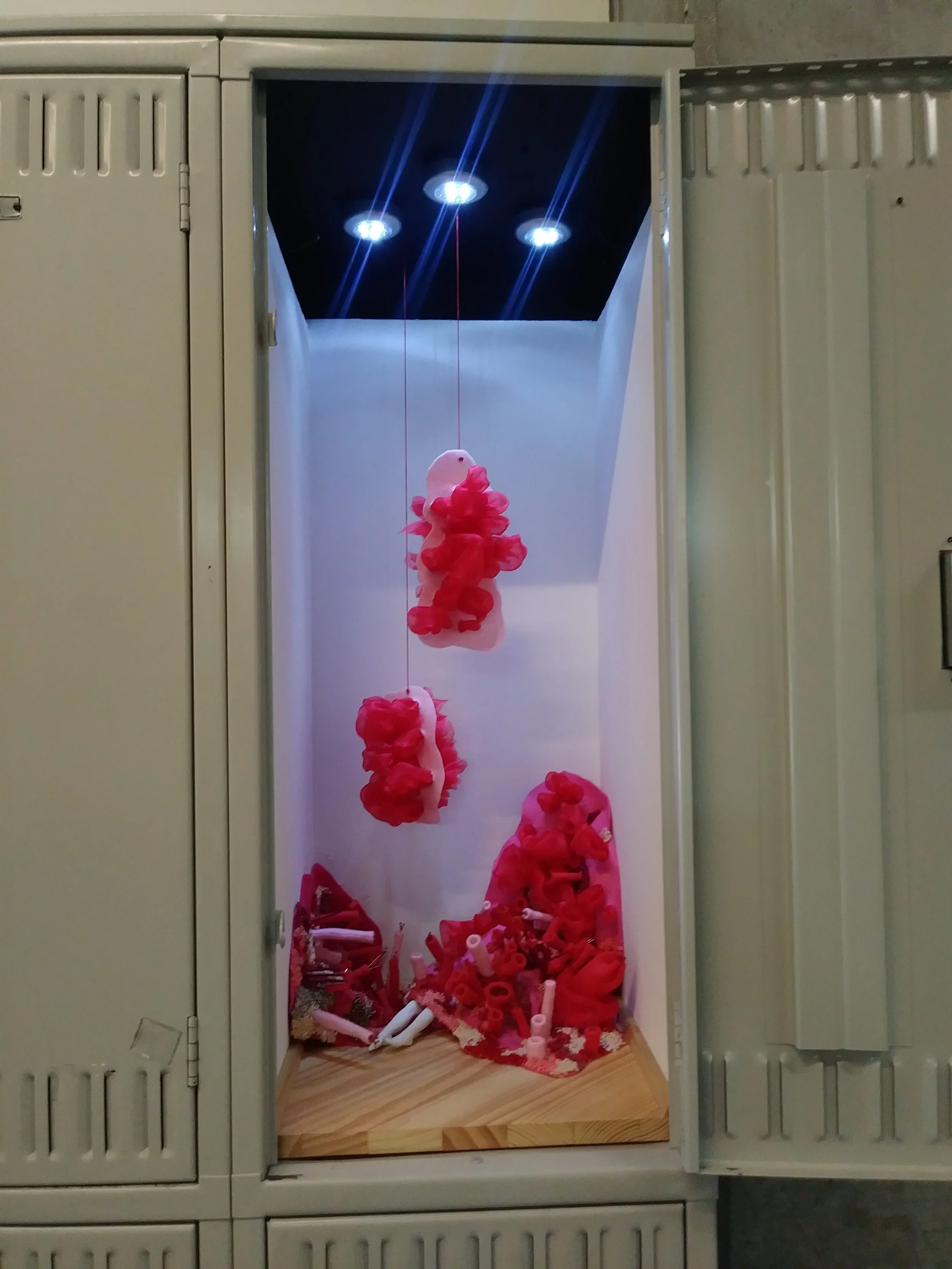 Colorful paper flowers arranged in a display inside a locker.