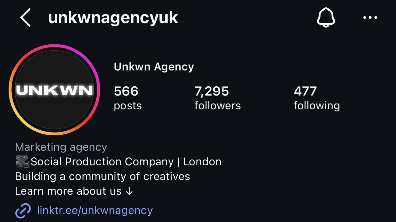Instagram profile page for 'unkwnagencyuk' showing a black circular profile picture with white text 'UNKWN', social media stats with 566 posts, 7,295 followers, and 477 following, with a bio describing it as a social production company in London.