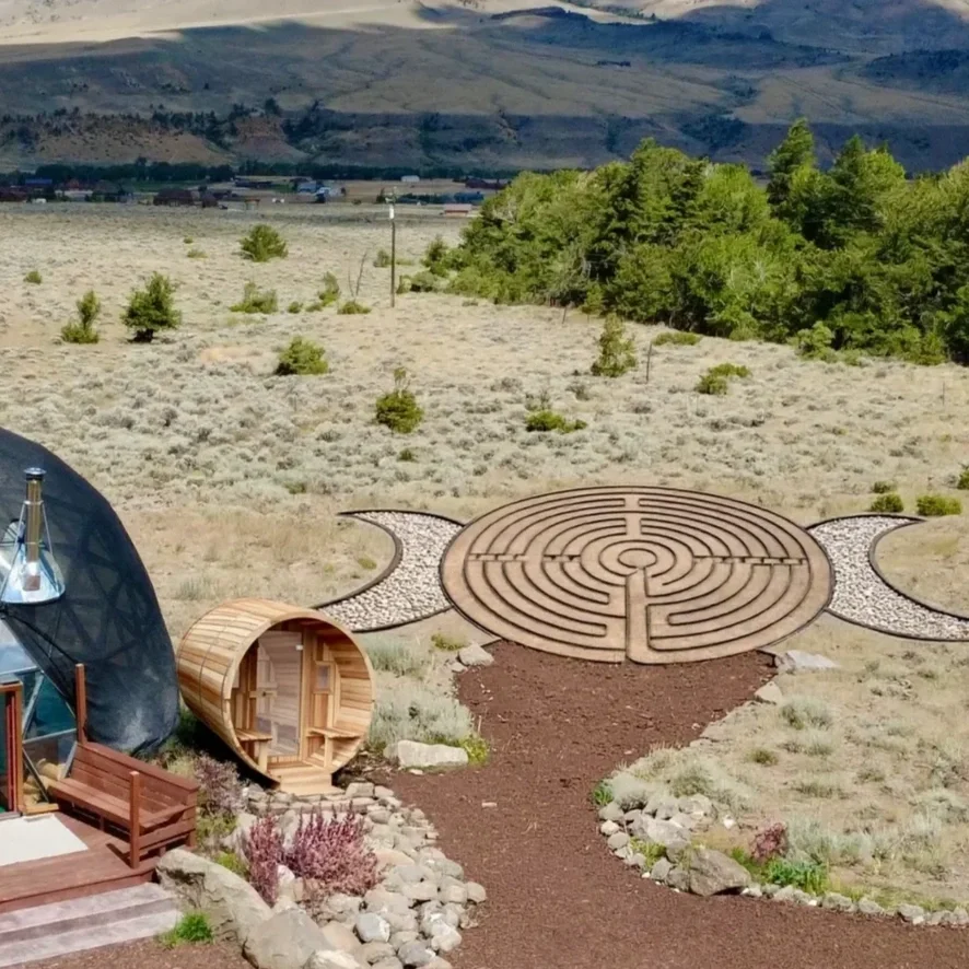 Pure Heart Retreat's labyrinth maze and barrle sauna with a mountain landscape in the background in Wapiti, WY.
